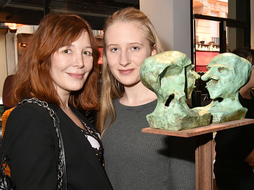Elise Depardieu et Louise Depardieu posent avec le portrait sculpté de Guillaume Depardieu par Roxanne lors de l'exposition "Mr. Otto Noselong" : Roxanne Depardieu Dessins et Peintures en avant-première à la Galerie Catherine Houard le 31 mars 2016 à Paris, France. | Photo : Getty Images.