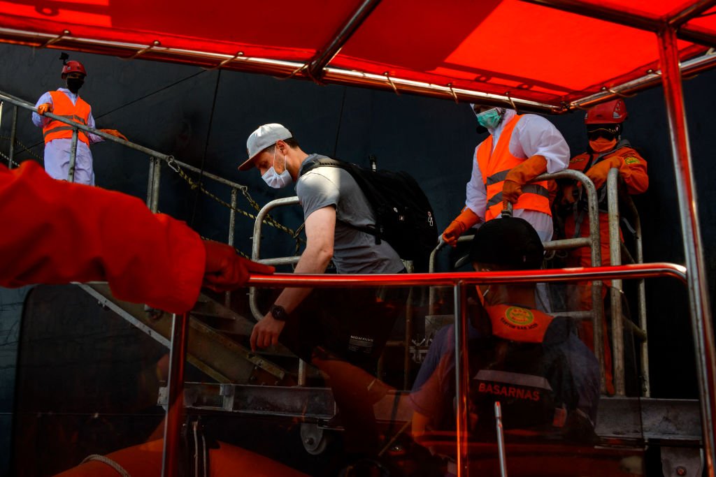Members of Indonesia's National Search And Rescue Agency (BASARNAS) assist Russian crew member, Alexander Melnik (C-white cap), from a dinghy after he was evacuated from the Danish tanker Hulda Maersk (not pictured) for medical reasons, at sea off the coast of Aceh on April 27, 2021 | Photo: Getty Images