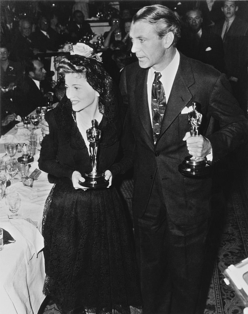 Joan Fontaine (1917 - 2013) holding her 'Best Actress' Oscar for her role in 'Suspicion', and American film actor, Gary Cooper, with his 'Best Actor' Oscar for his role in 'Sergeant York' at the 14th Academy Awards at the Biltmore Bowl, Los Angeles Biltmore Hotel, USA, 26th February 1942. | Source: Getty Images