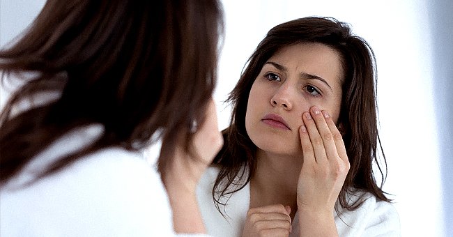Une femme se regarde dans le miroir. | Photo : shutterstock