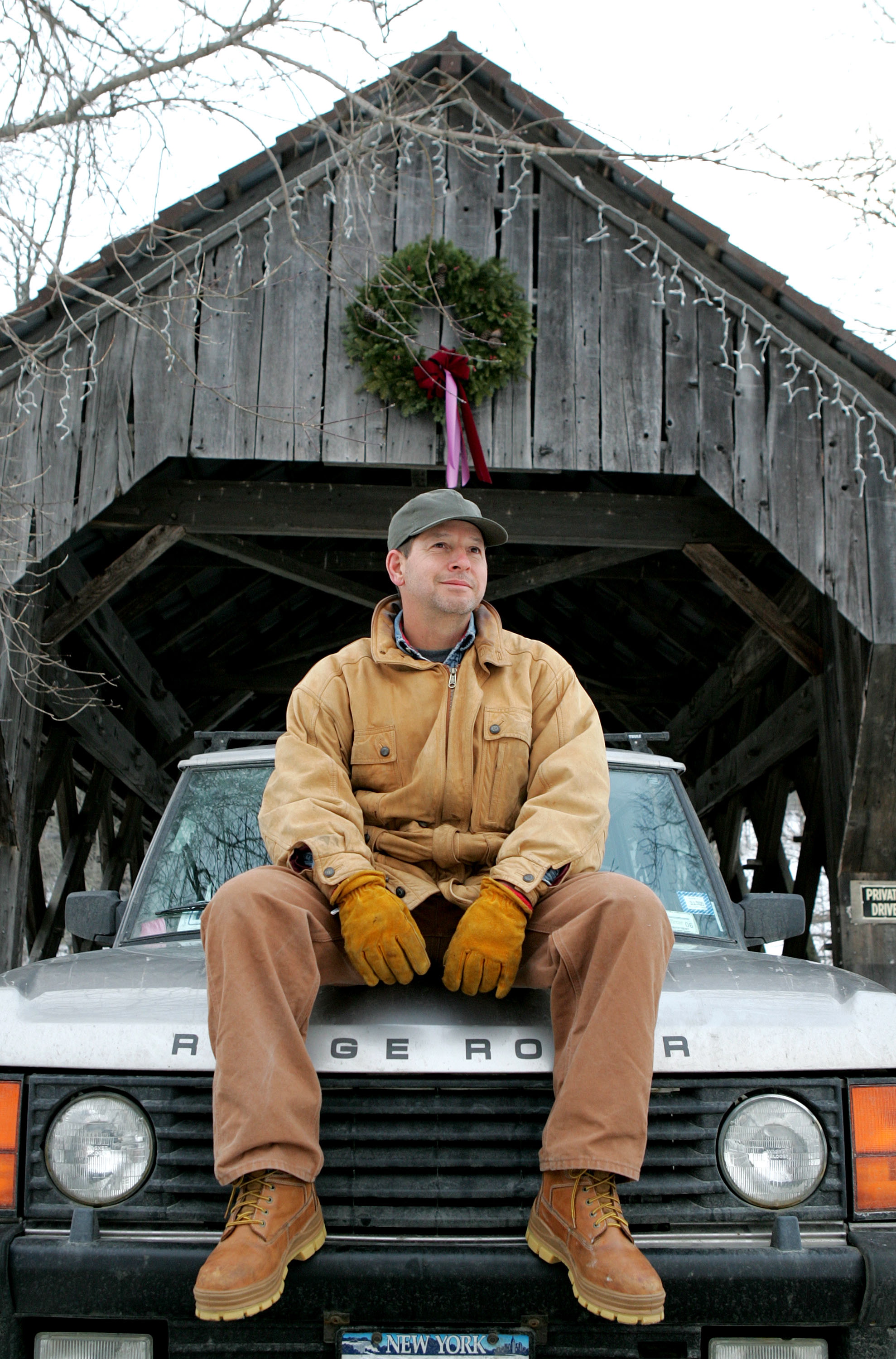 Ron Galotti sits on his Range Rover in front of a covered bridge on January 19, 2005, in North Pomfret, Vermont. | Source: Getty Images