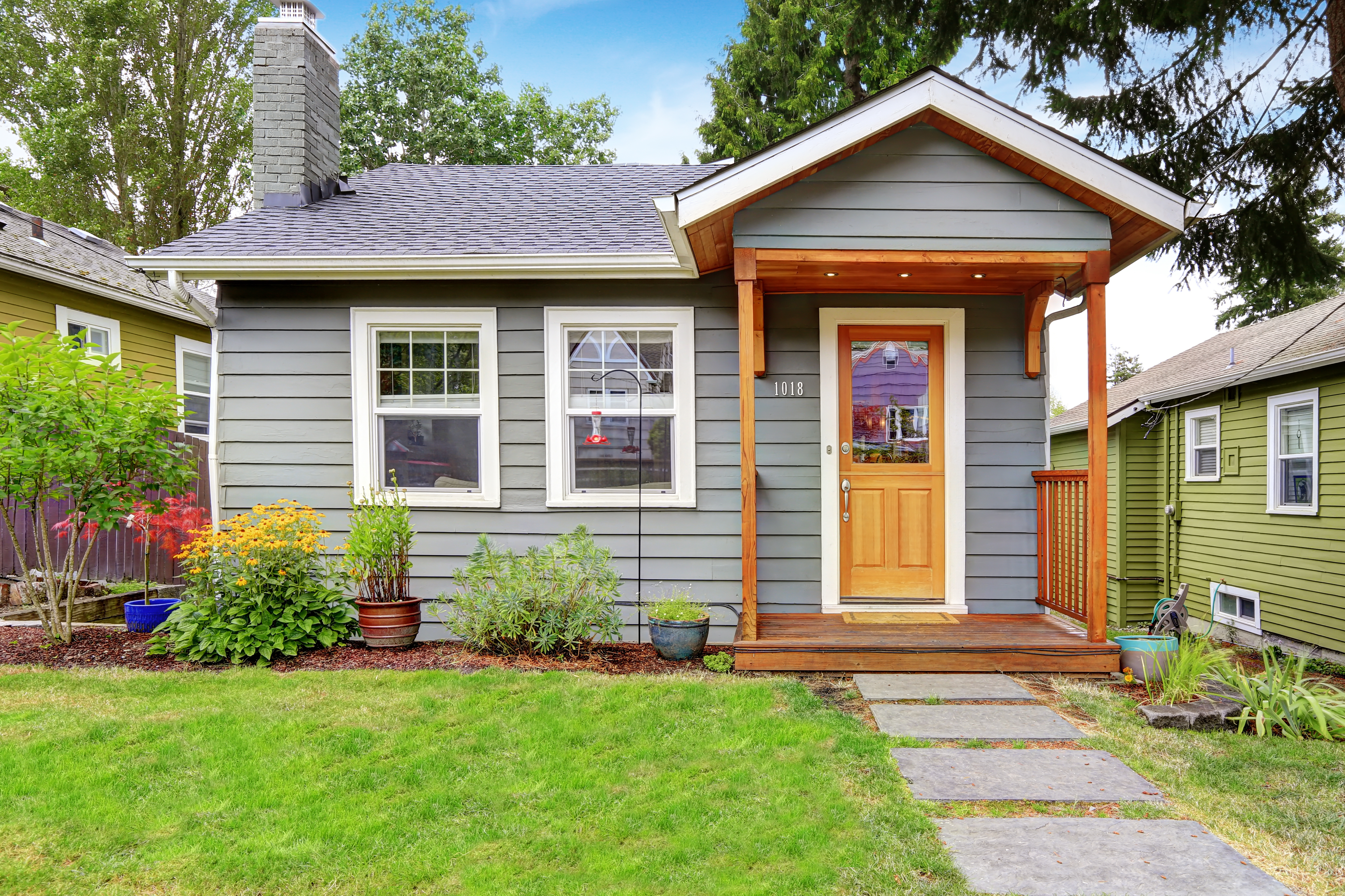 Small grey house with wooden deck. | Source: Shutterstock