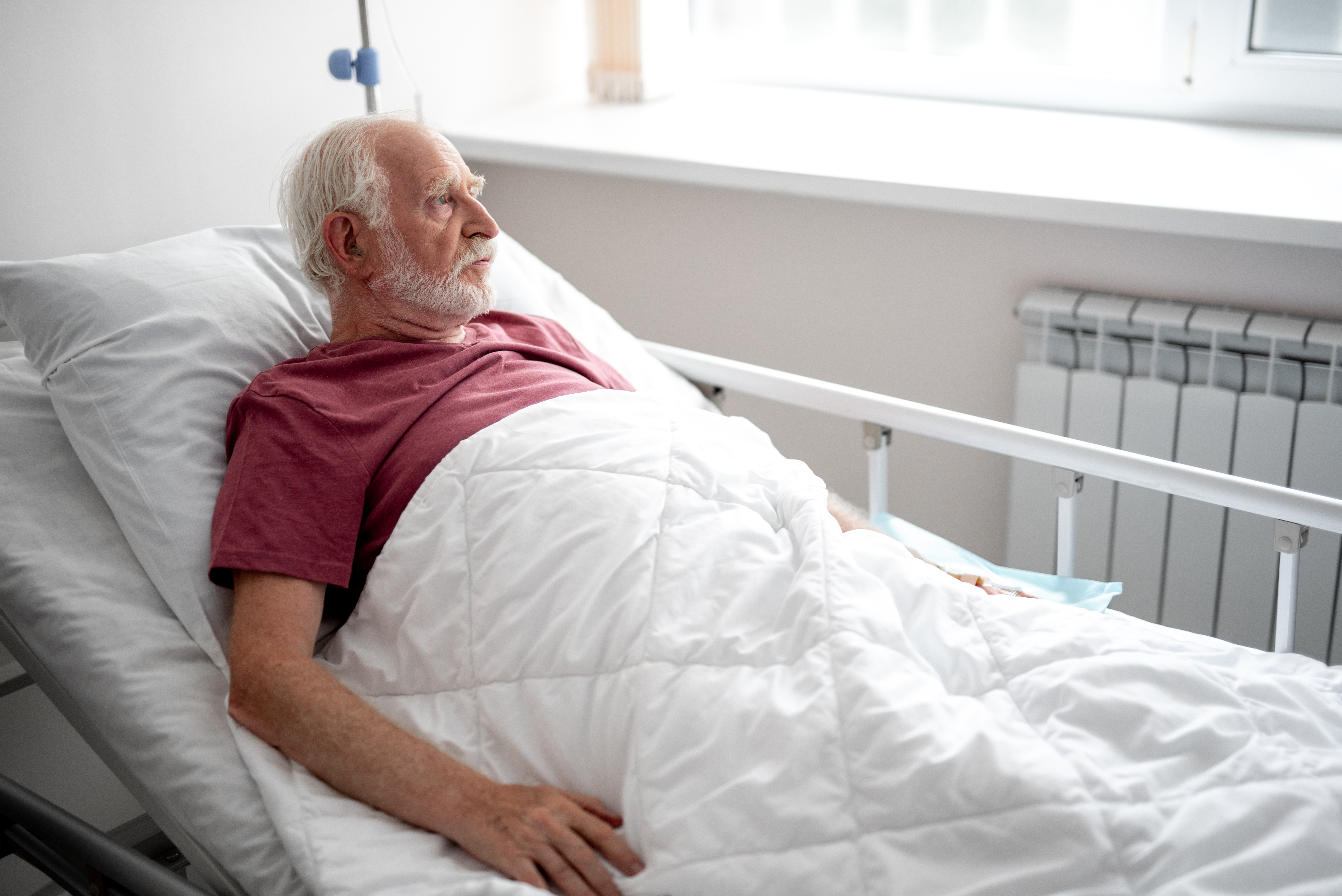 An elderly man laying in a hospital bed | Source: Getty Images