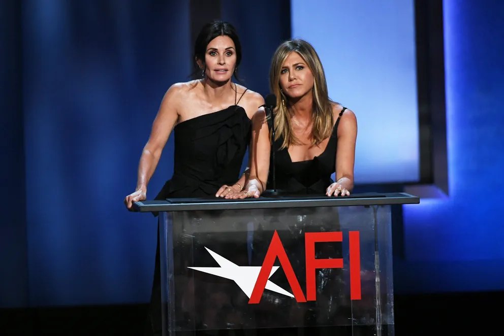 Courteney Cox (à gauche) et Jennifer Aniston parlent sur scène lors du 46e gala du Life Achievement Award de l'American Film Institute en hommage à George Clooney, au Dolby Theatre, le 7 juin 2018 à Hollywood, en Californie. | Source : Getty Images