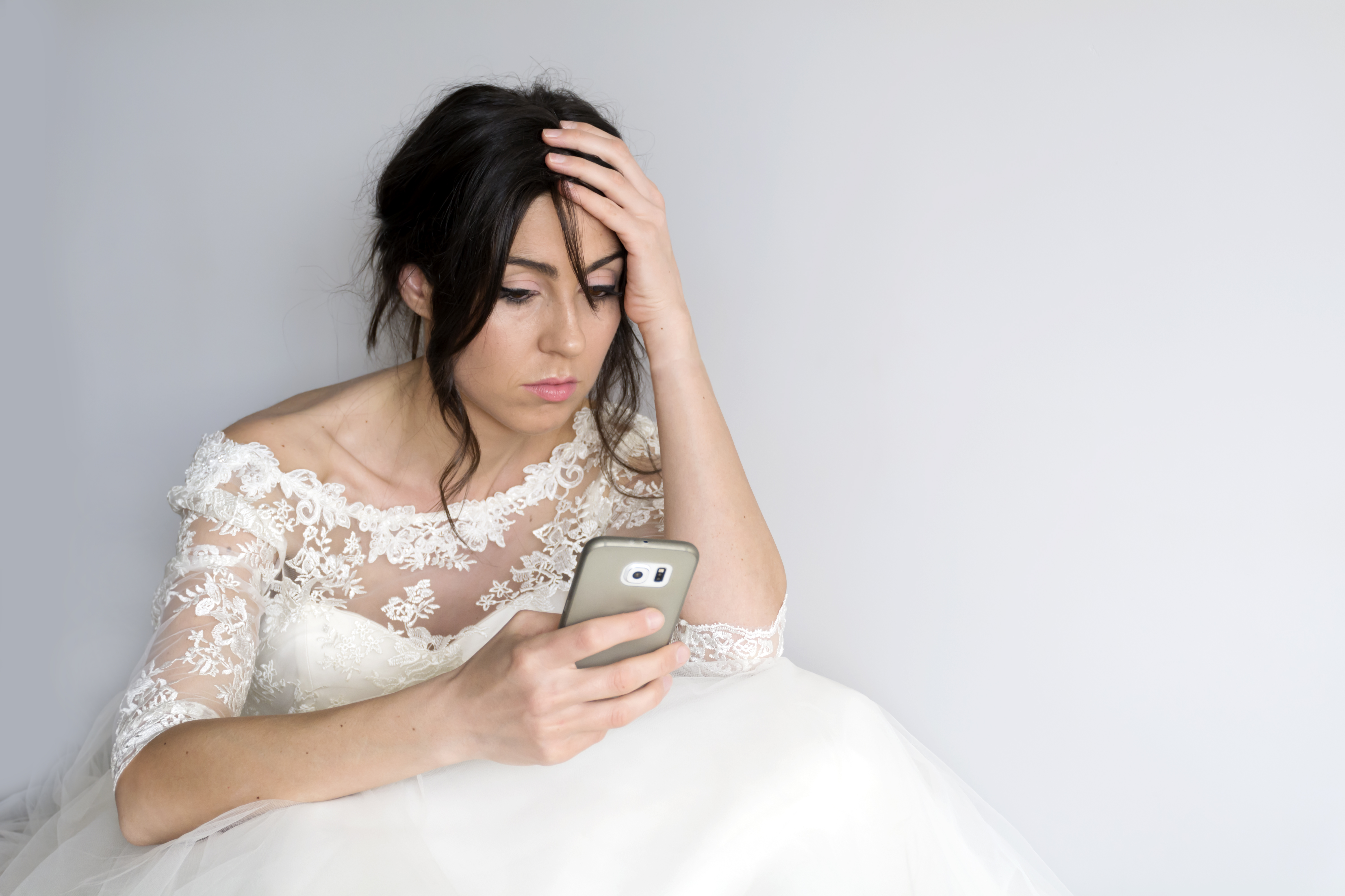 Sad bride looking at her phone | Source: Getty Images