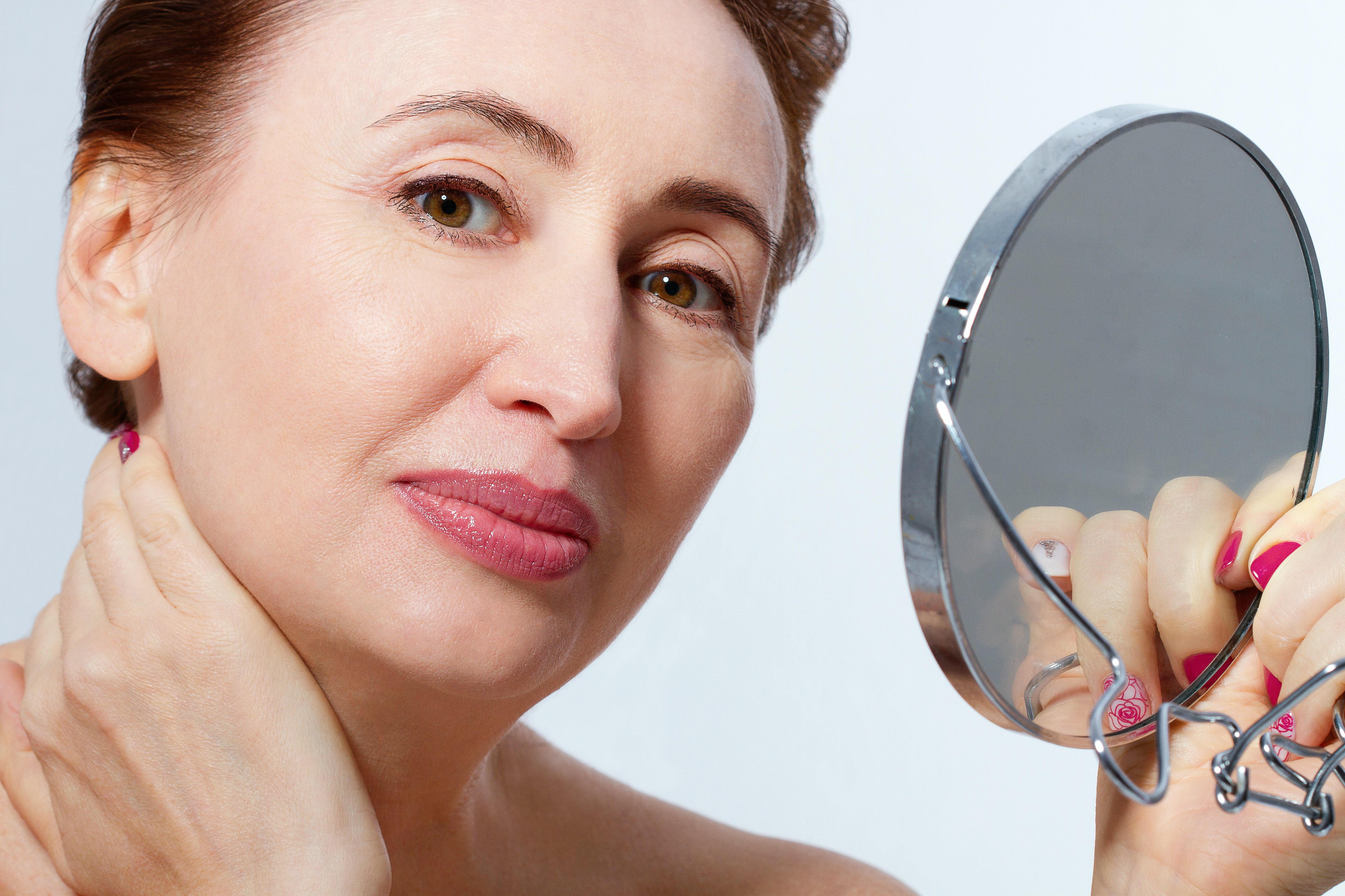 Une femme de 50 ans devant un miroir | souce : shutterstock