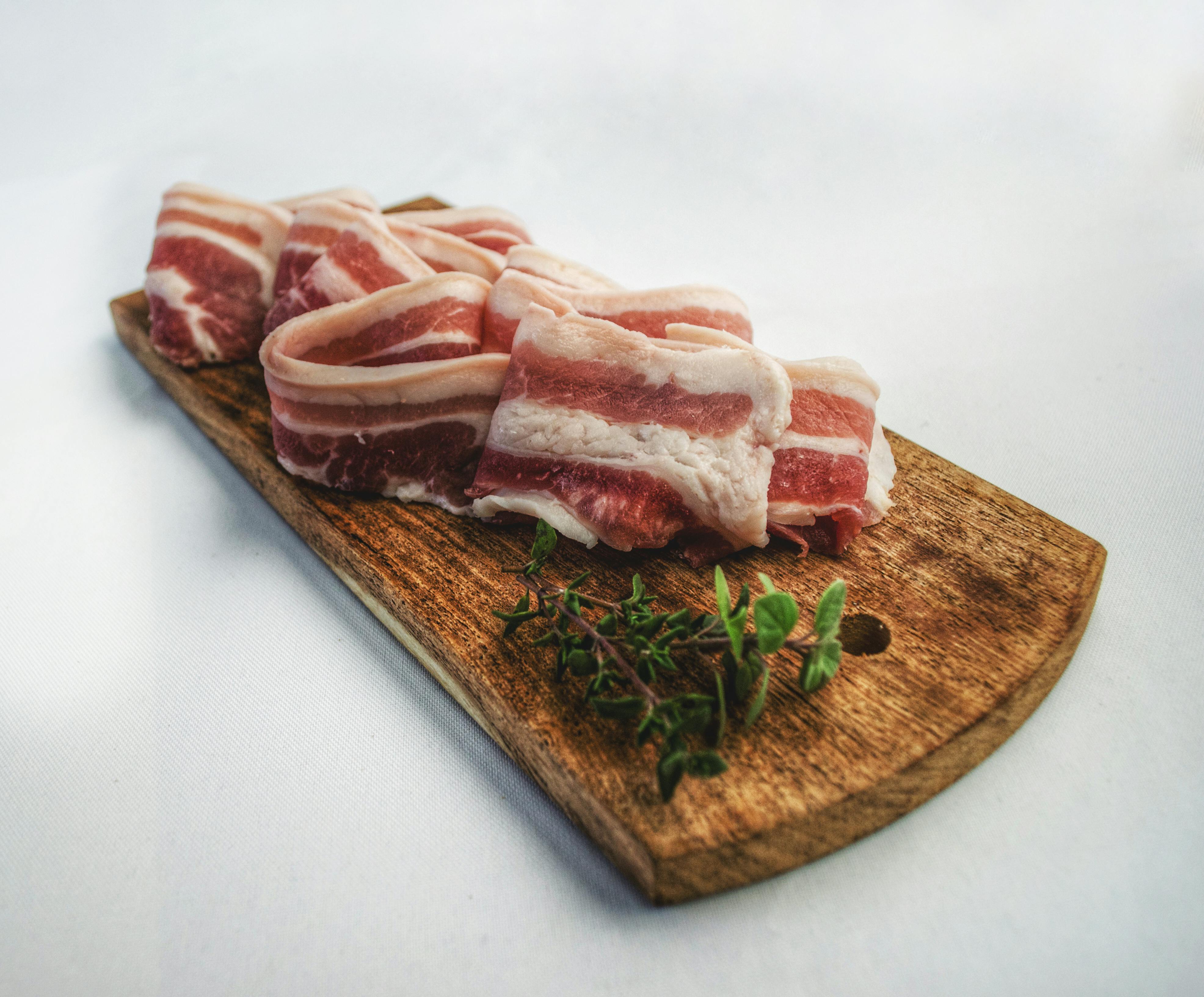Sliced bacon on top of a brown chopping board. | Source: Pexels