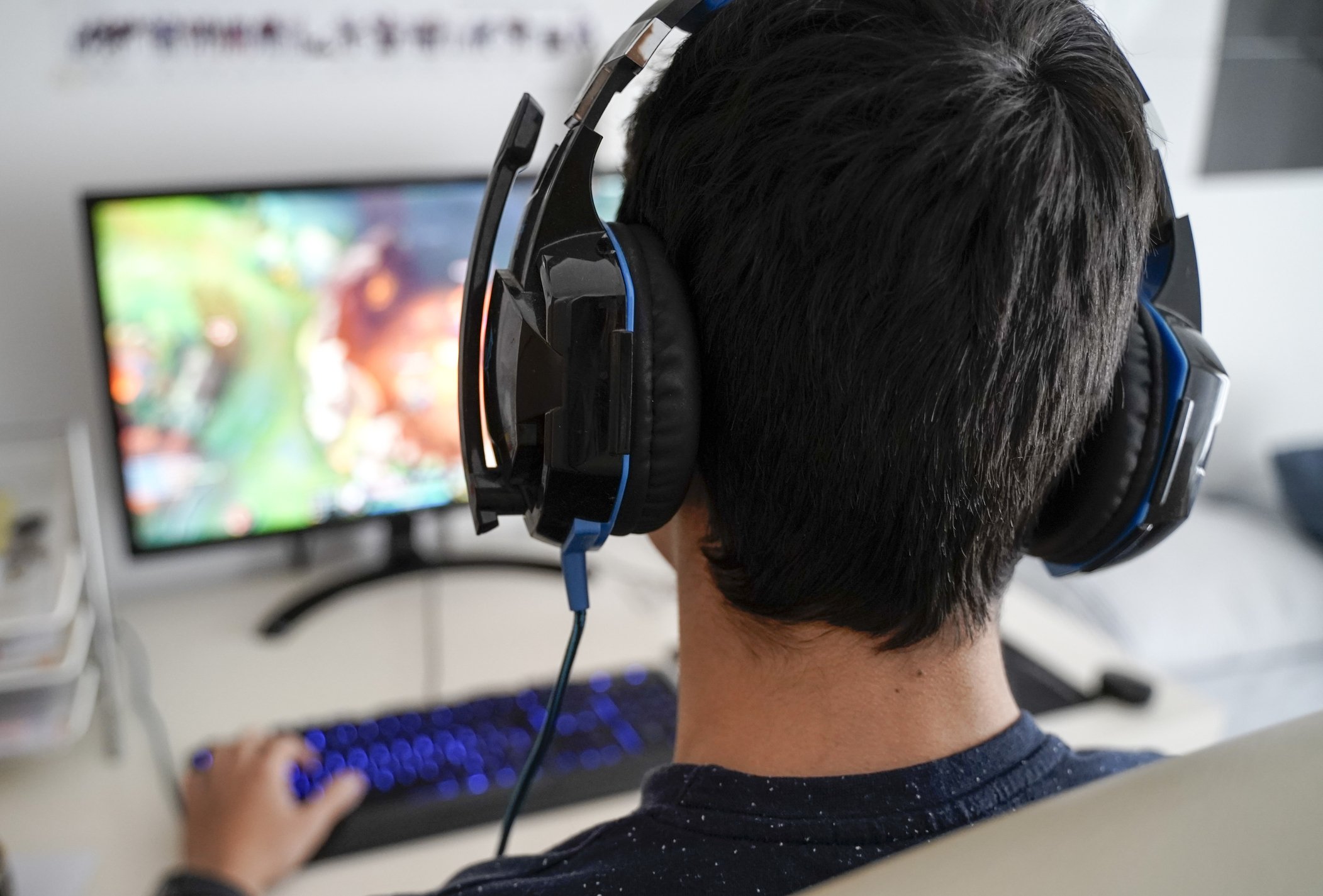 Mann mit Kopfhörern, die auf seinem Computer spielen | Quelle: Getty Images