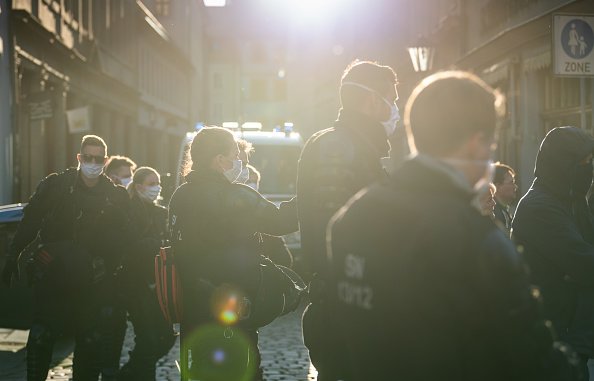 Des policiers se tiennent en marge d'une manifestation d'opposants aux mesures de la Corona. | Photo : Getty Images Des policiers se tiennent en marge d'une manifestation d'opposants aux mesures de la Corona. | Photo : Getty Images