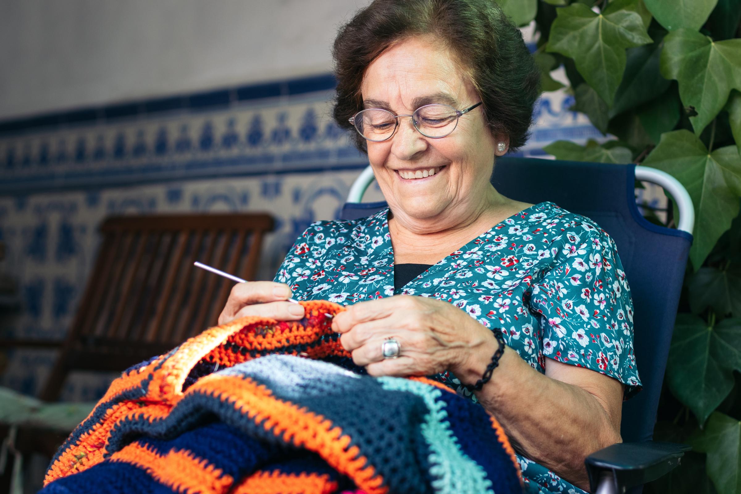 An older woman happily knitting | Source: Shutterstock