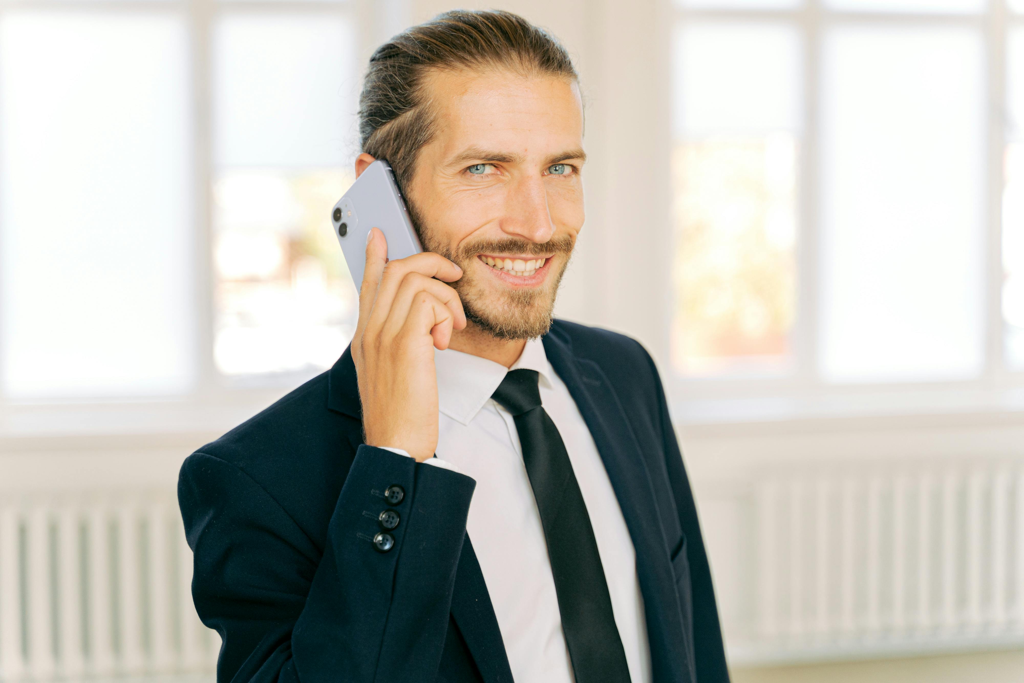 A smiling man on a phone call | Source: Pexels