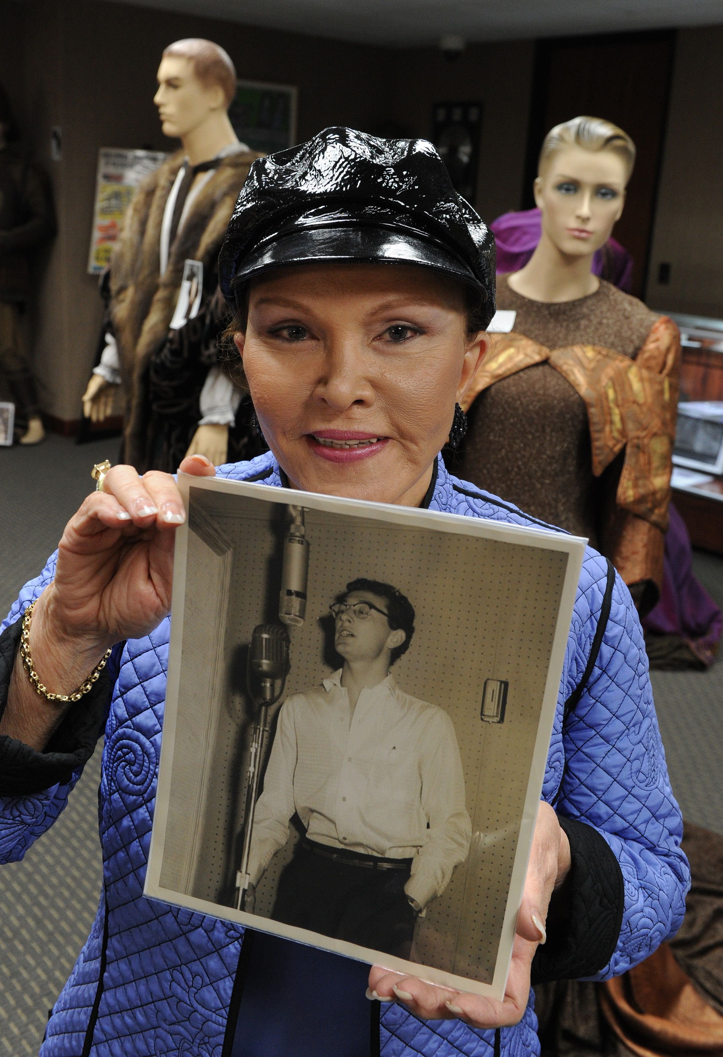 Maria Elena Holly holds a studio photo of Buddy Holly before an auction of the late singers memorabilia at the Heritage Auction Gallery in Beverly Hills on April 9, 2010. | Source: Getty Images