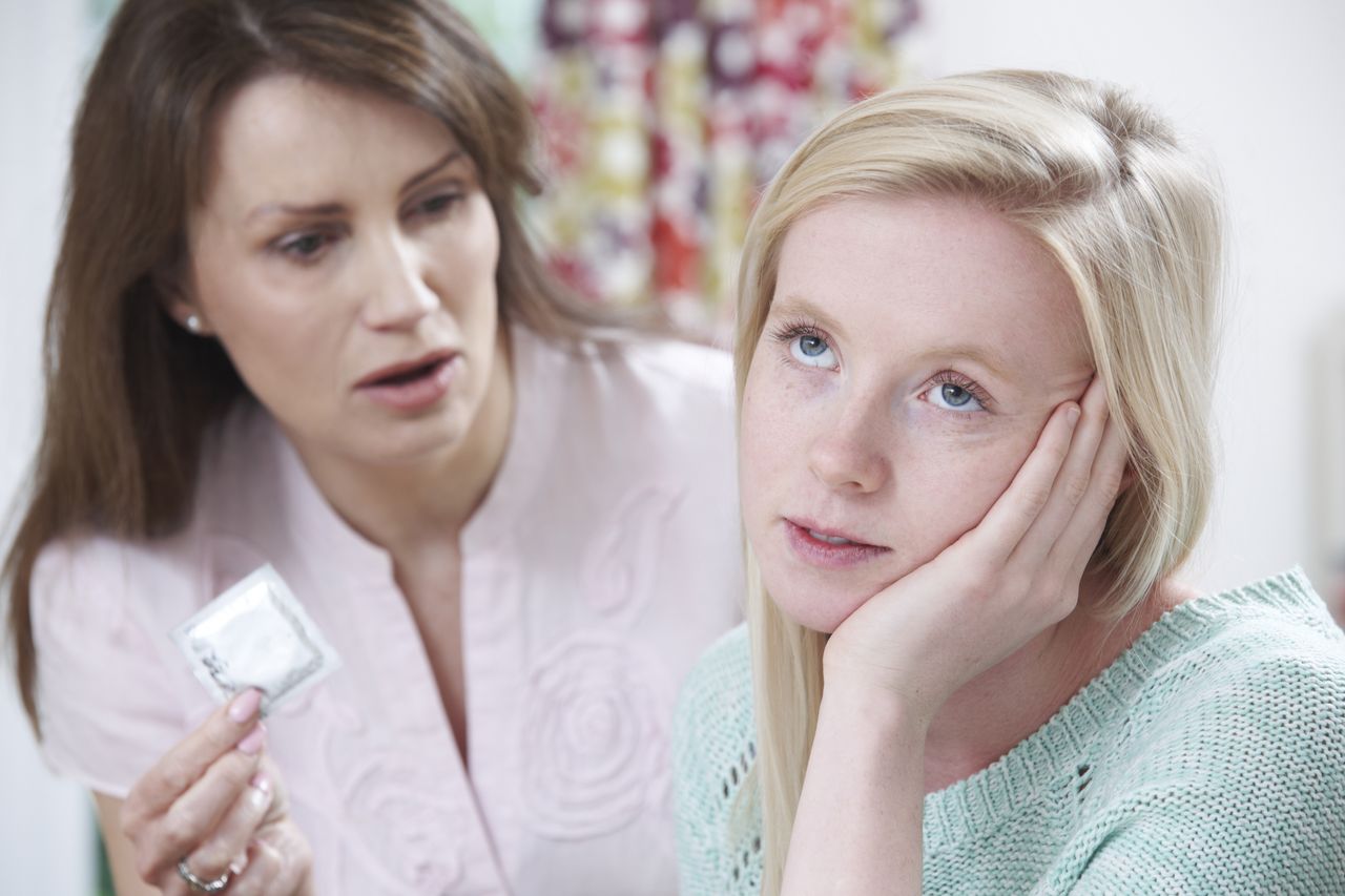 A mother gets mad at her daughter while holding a condom. | Source: Shutterstock