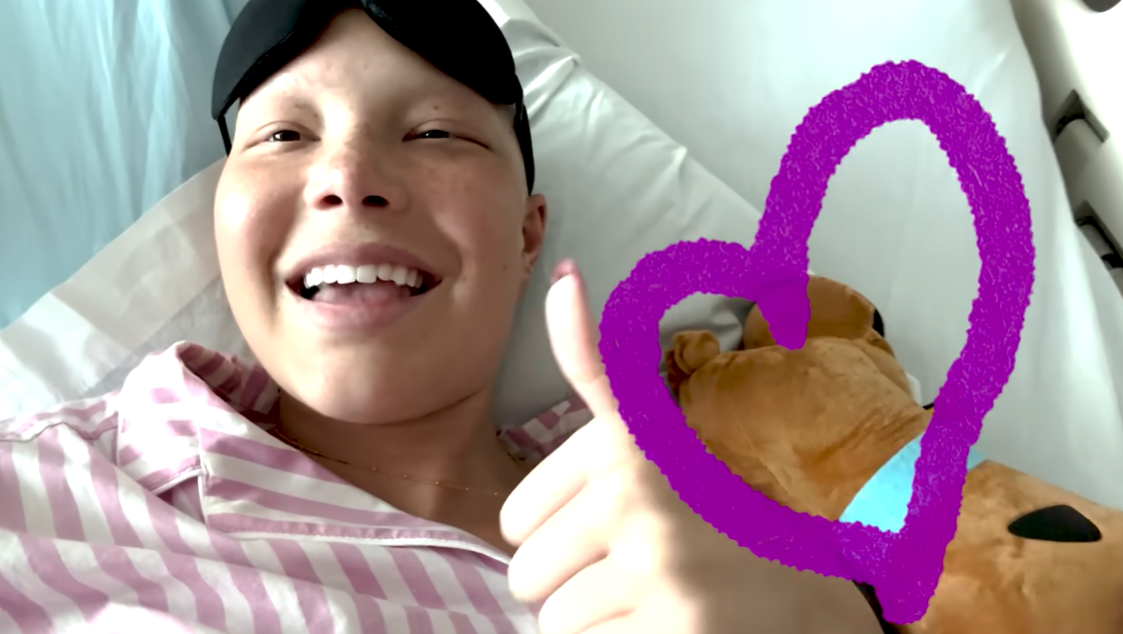 Isabella smiles and gives a thumbs-up as she announces she has completed her chemotherapy, June 2024. | Source: YouTube/IsabellaStrahan