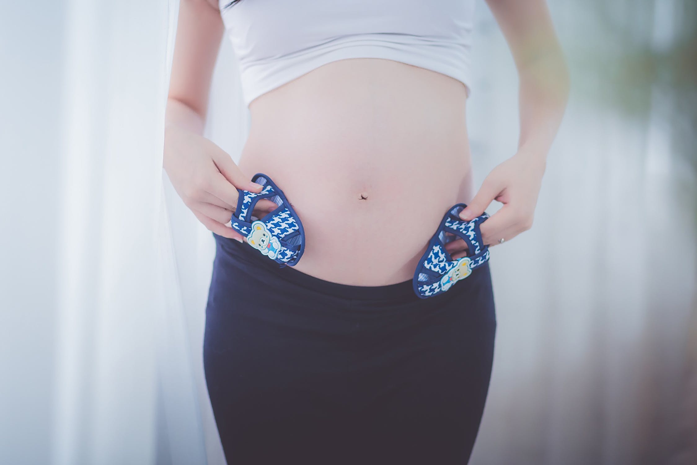 Mujer embarazada mostrando su vientre abultado con pequeños zapatos en sus manos. | Imagen: Pexels Mujer embarazada mostrando su vientre abultado con pequeños zapatos en sus manos. | Imagen: Pexels