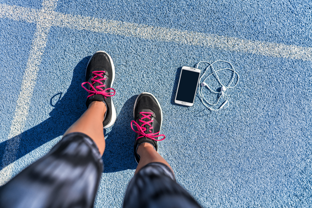 A pair of legs and a phone on the floor | Source: Shutterstock