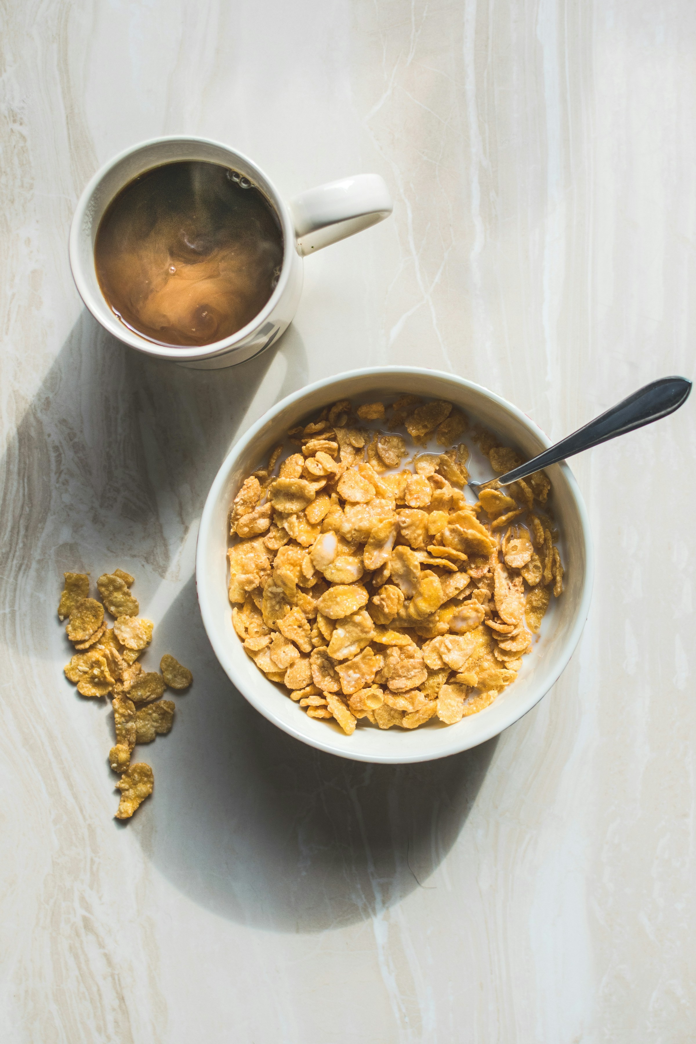 A bowl of cereal and a mug of coffee | Source: Unsplash