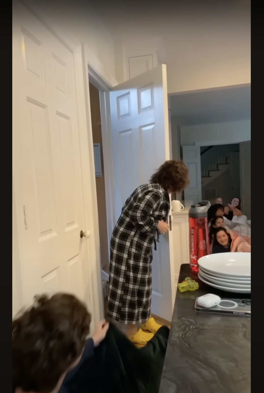Joy McGrath is shocked to see the graduating class of 2023 sprawled on her kitchen floor, as seen in a video dated May 20, 2023 | Source: youtube.com/SASDelaware