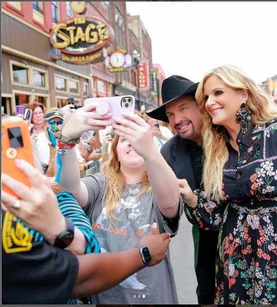 A photo of Trisha Yearwood and her husband Garth Brooks interacting with fans posted on August 23, 2024 | Source: Instagram/trishayearwood