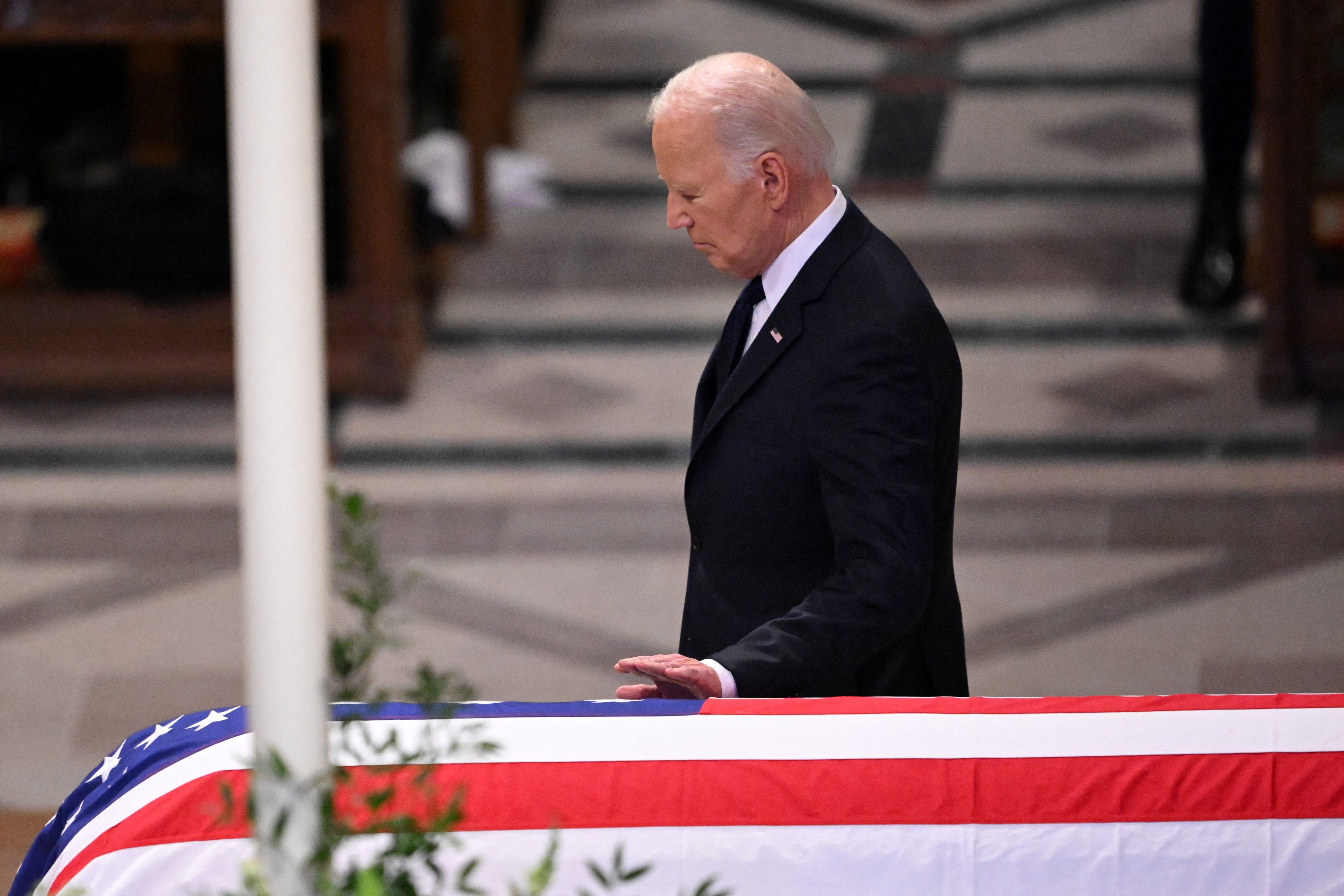 Joe Biden touches the casket after delivering the eulogy at the State Funeral for former U.S. President Jimmy Carter | Source: Getty Images