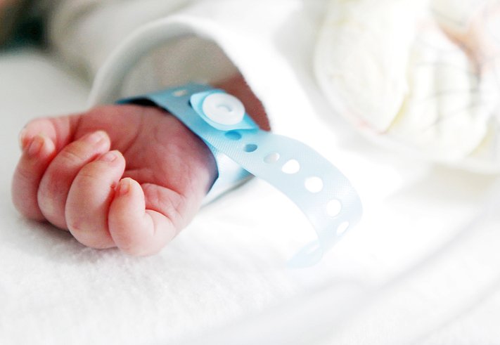 Cropped Hand Of Newborn Baby With Name Tag | Photo: Getty Images