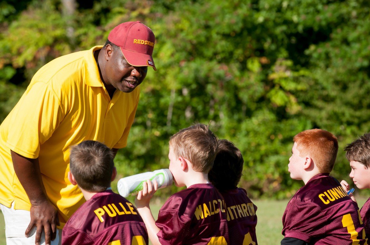 Entrenador hablando con los miembros de un equipo de fútbol infantil. | Foto: PxHere