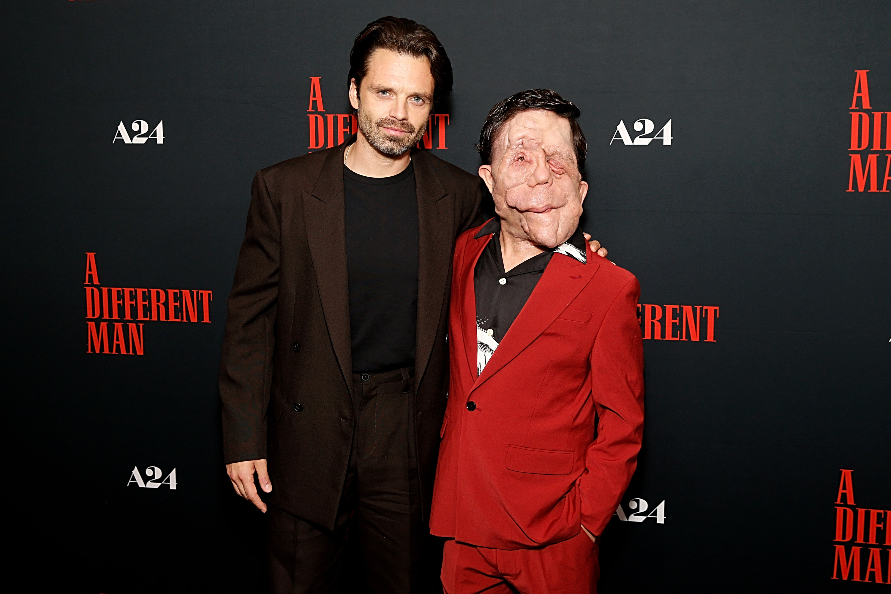 Sebastian Stan and Adam Pearson pictured together at the New York screening of "A Different Man" on 17 September 2024. Pearson wore a red double-breasted suit jacket with a patterned shirt underneath, while Stan, who had his arm around Pearson's shoulder,  donned an all-black outfit. Pearson starred alongside Stan in the film, which brought the former some of his most prominent recognition to date.
