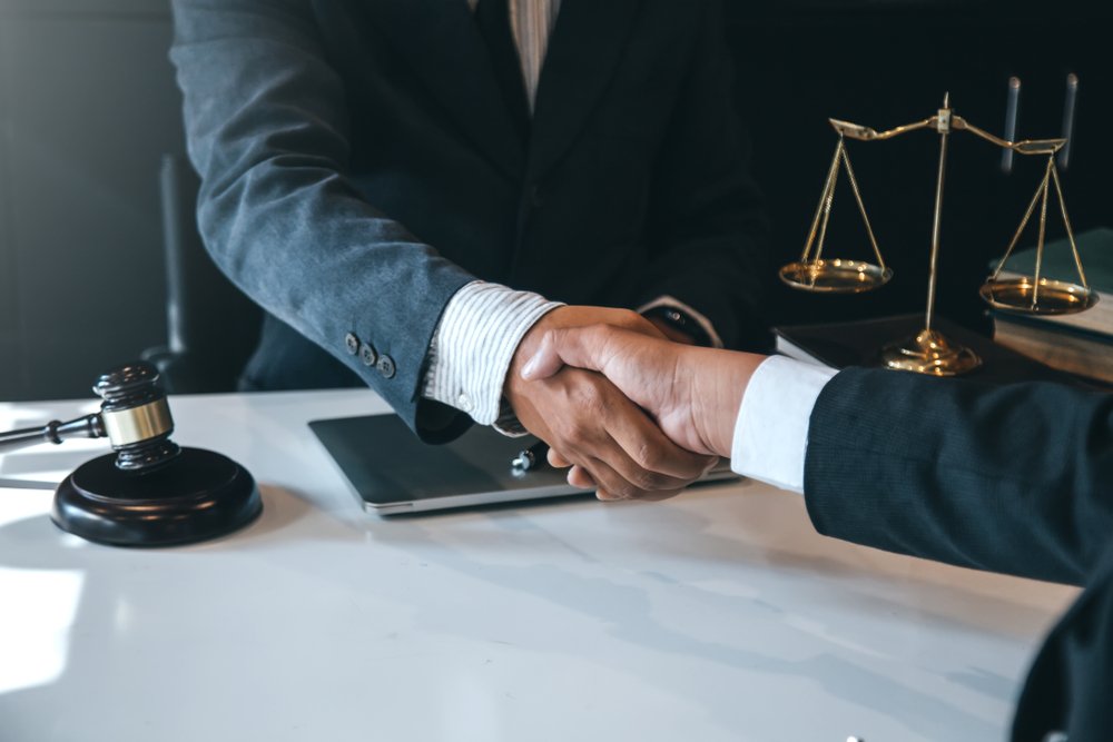 The attorney and client shaking hands to a settled case | Photo: Shutterstock
