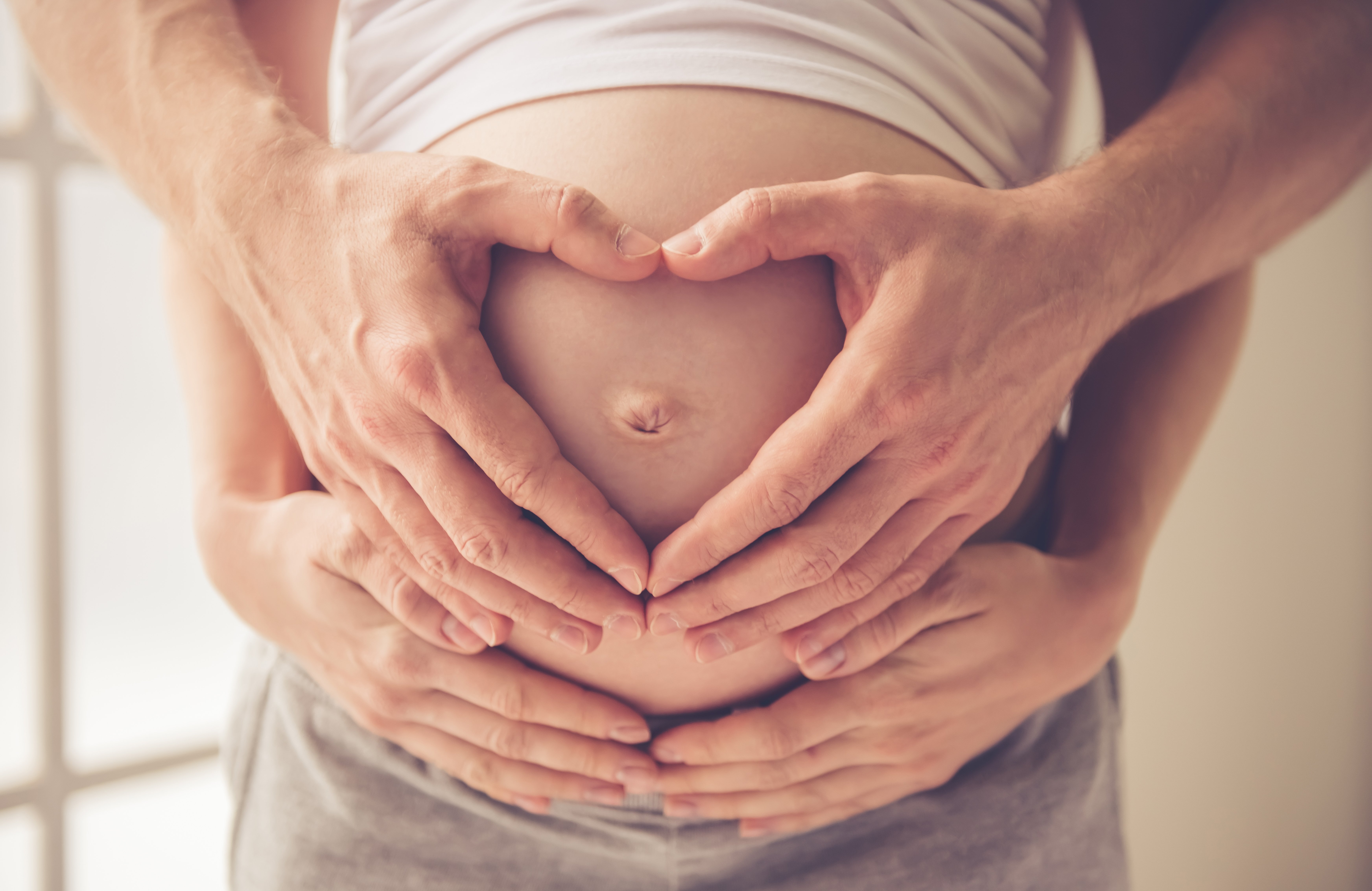 Hands on pregnant stomach | Source: Shutterstock