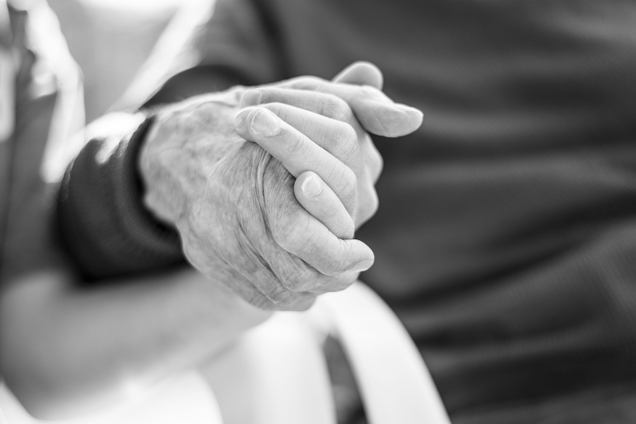 An older man holding a young person's hand | Source: Pexels