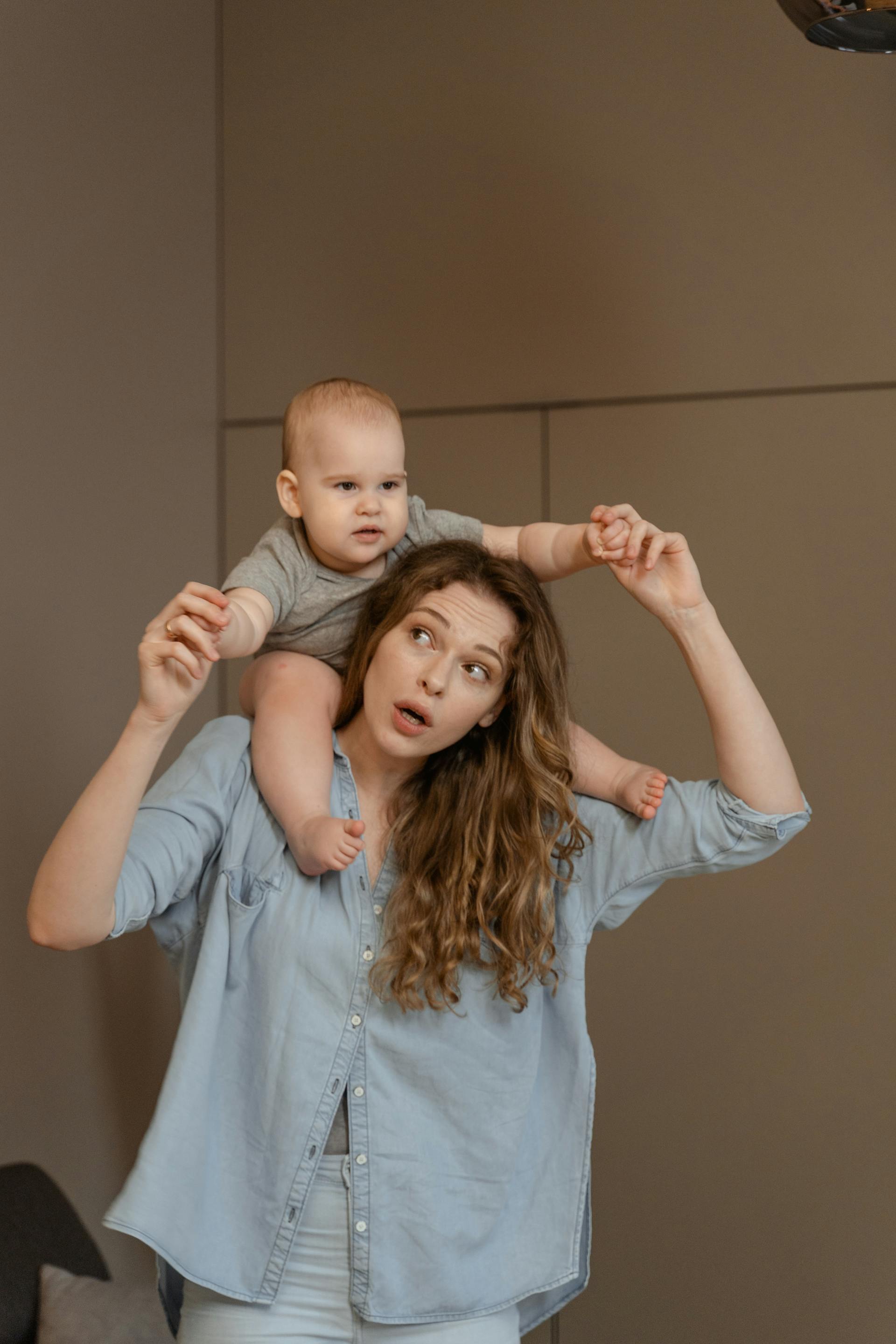 A woman carrying a toddler on her shoulder | Source: Pexels