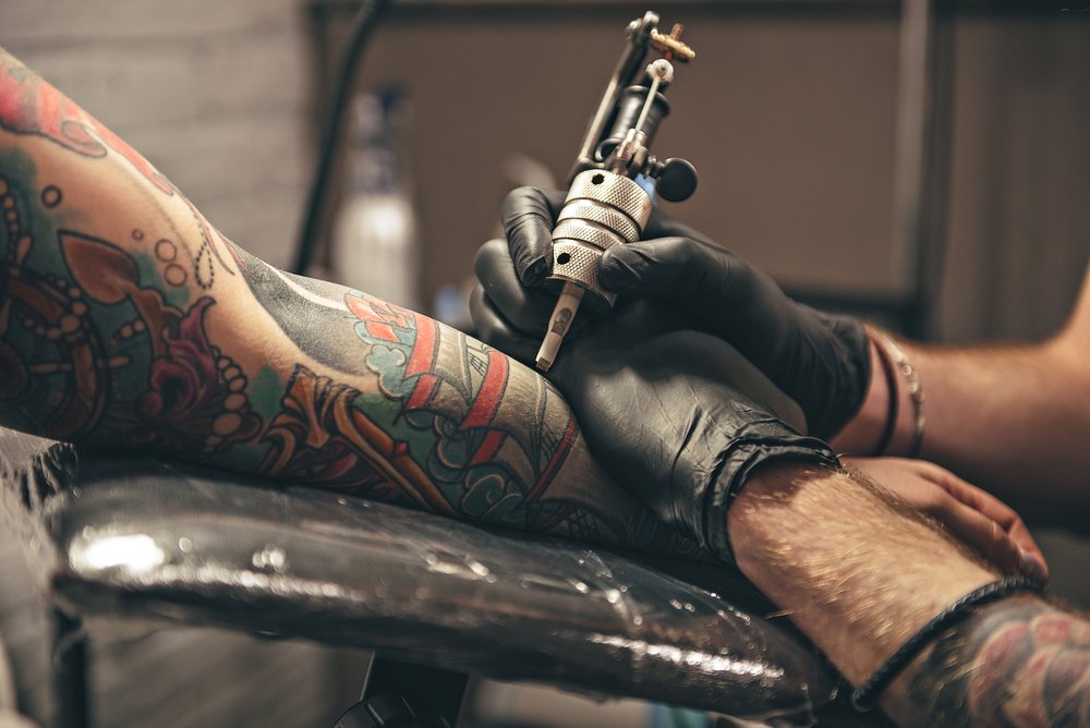 A man getting a tattoo from an artist. | Photo: Shutterstock