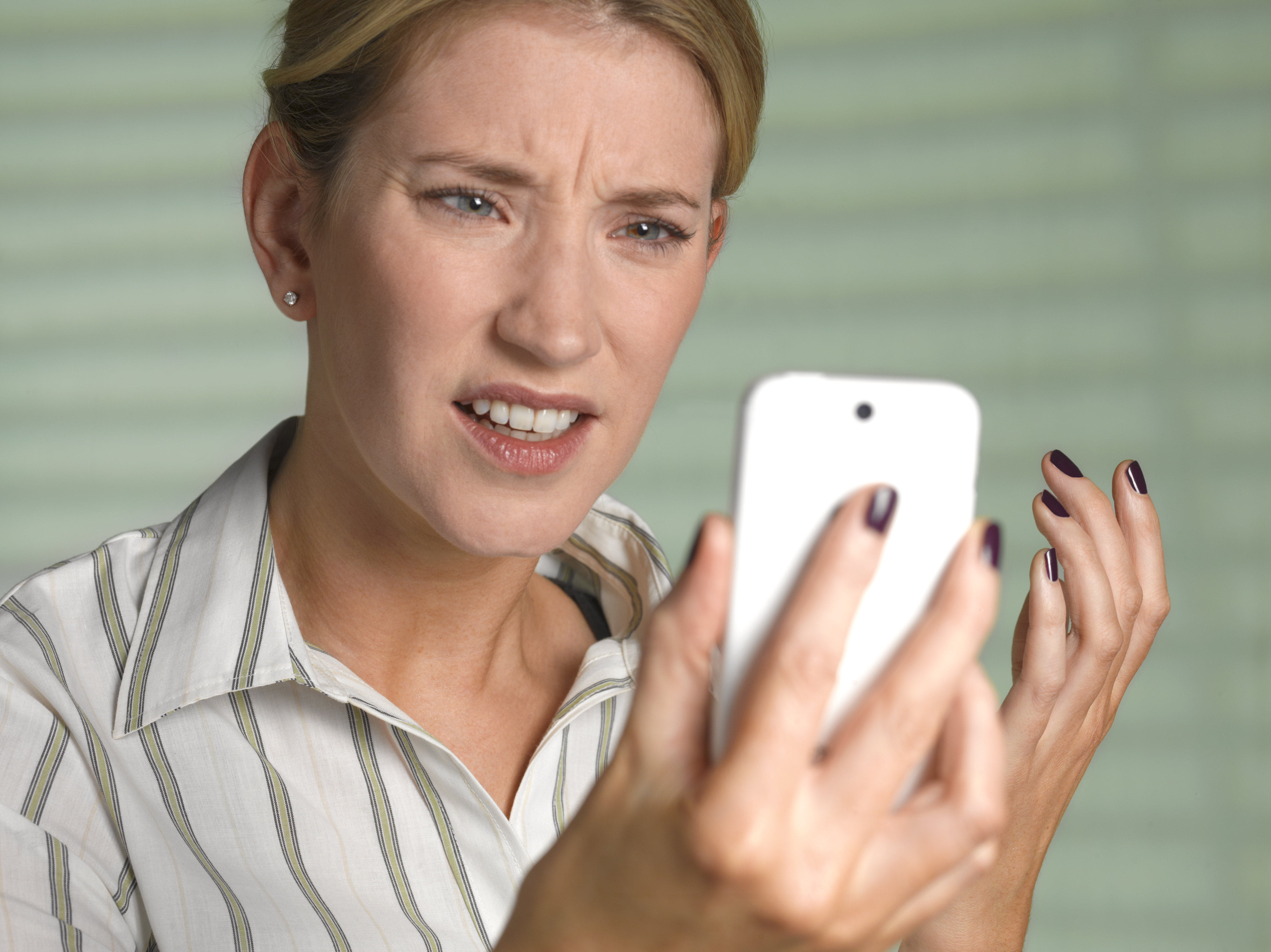 A confused and upset woman looking at a phone | Source: Getty Images