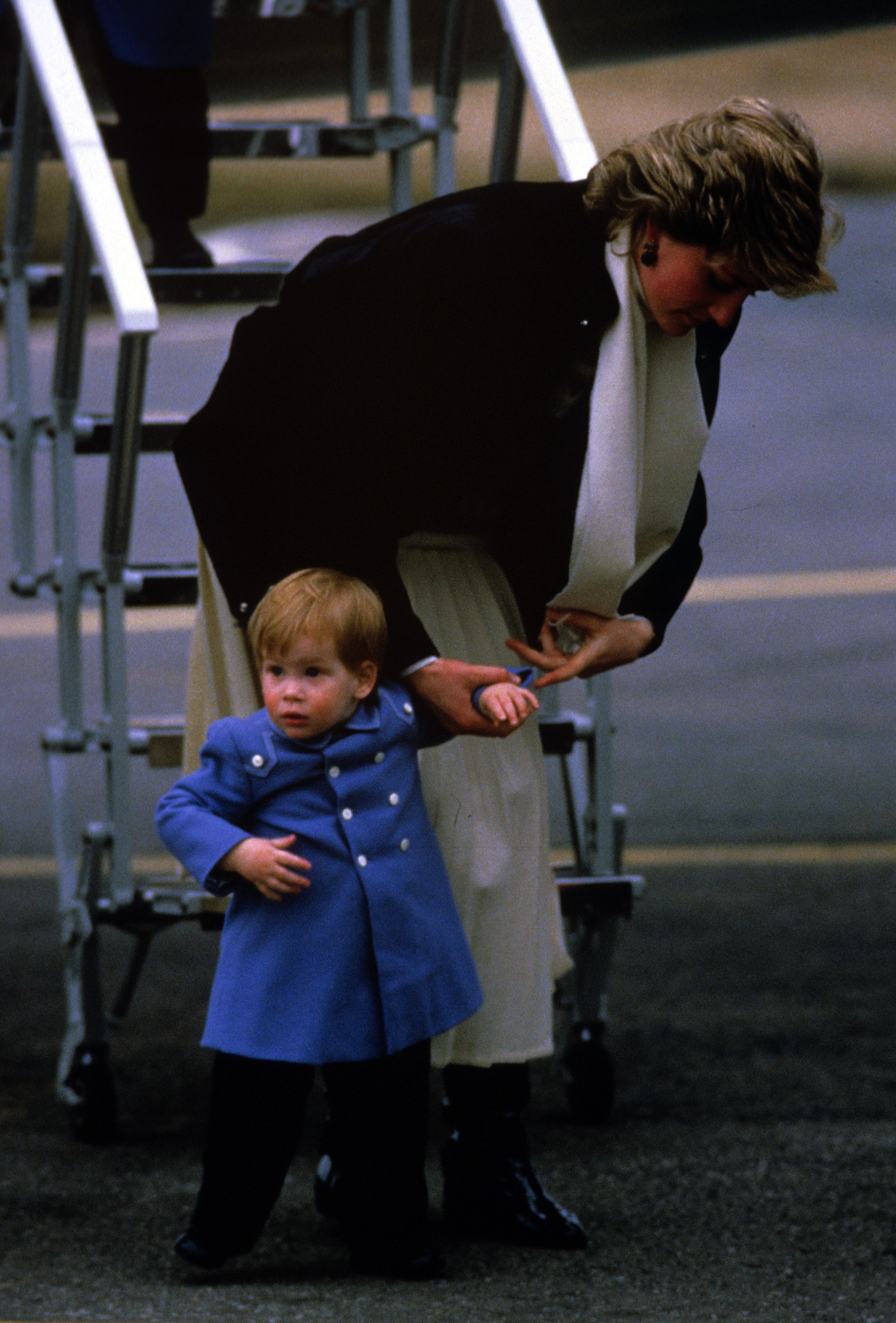 Diana, Princesa de Gales, junto al pequeño Príncipe Harry a su llegada al Aeropuerto de Aberdeen en marzo de 1986, en Escocia || Fuente: Getty Images