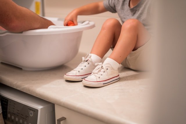 Un enfant assis à côté du lavabo de la baignoire | Source : Unsplash