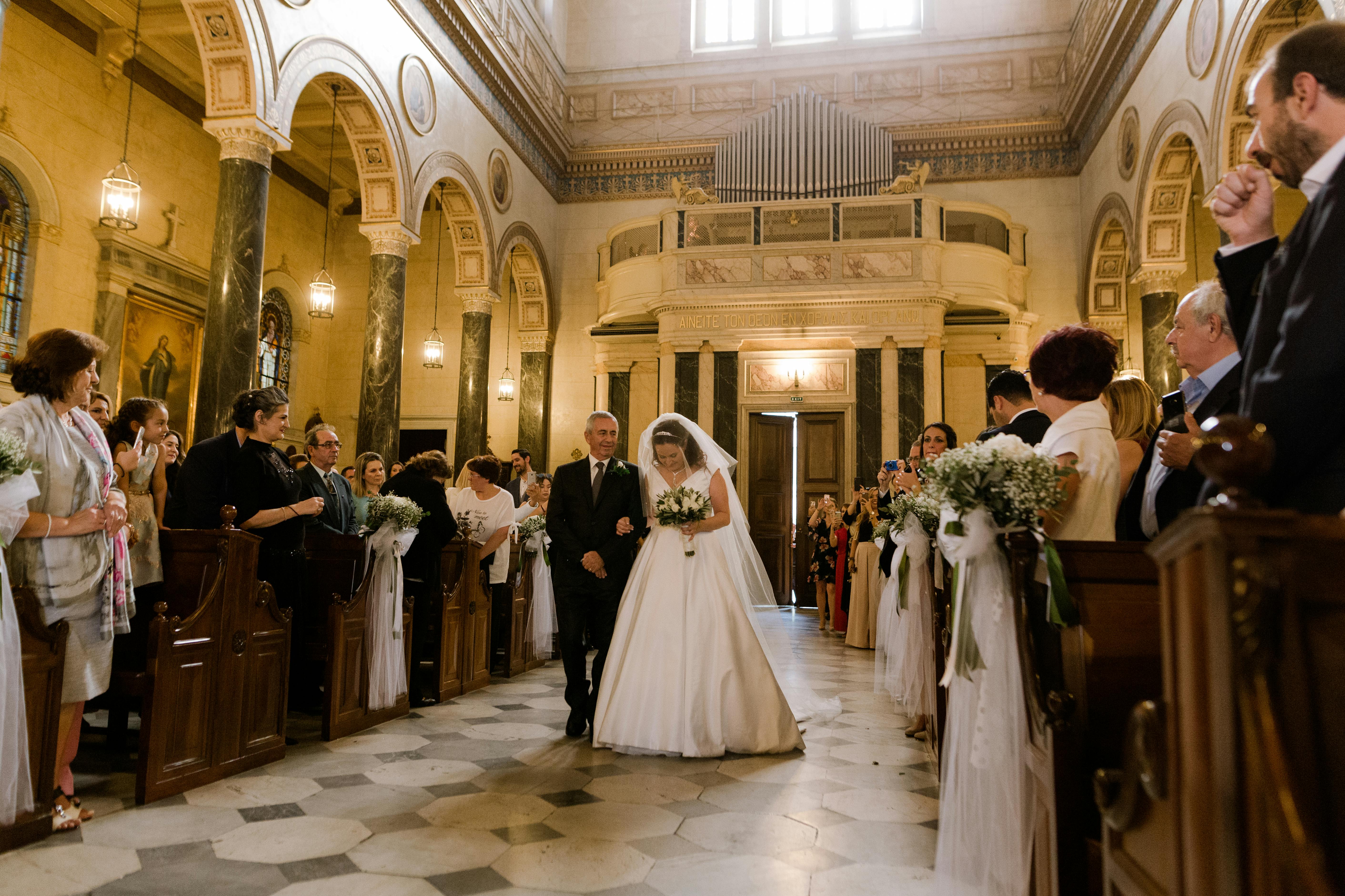 A man walks a bride down a church aisle | Source: Pexels