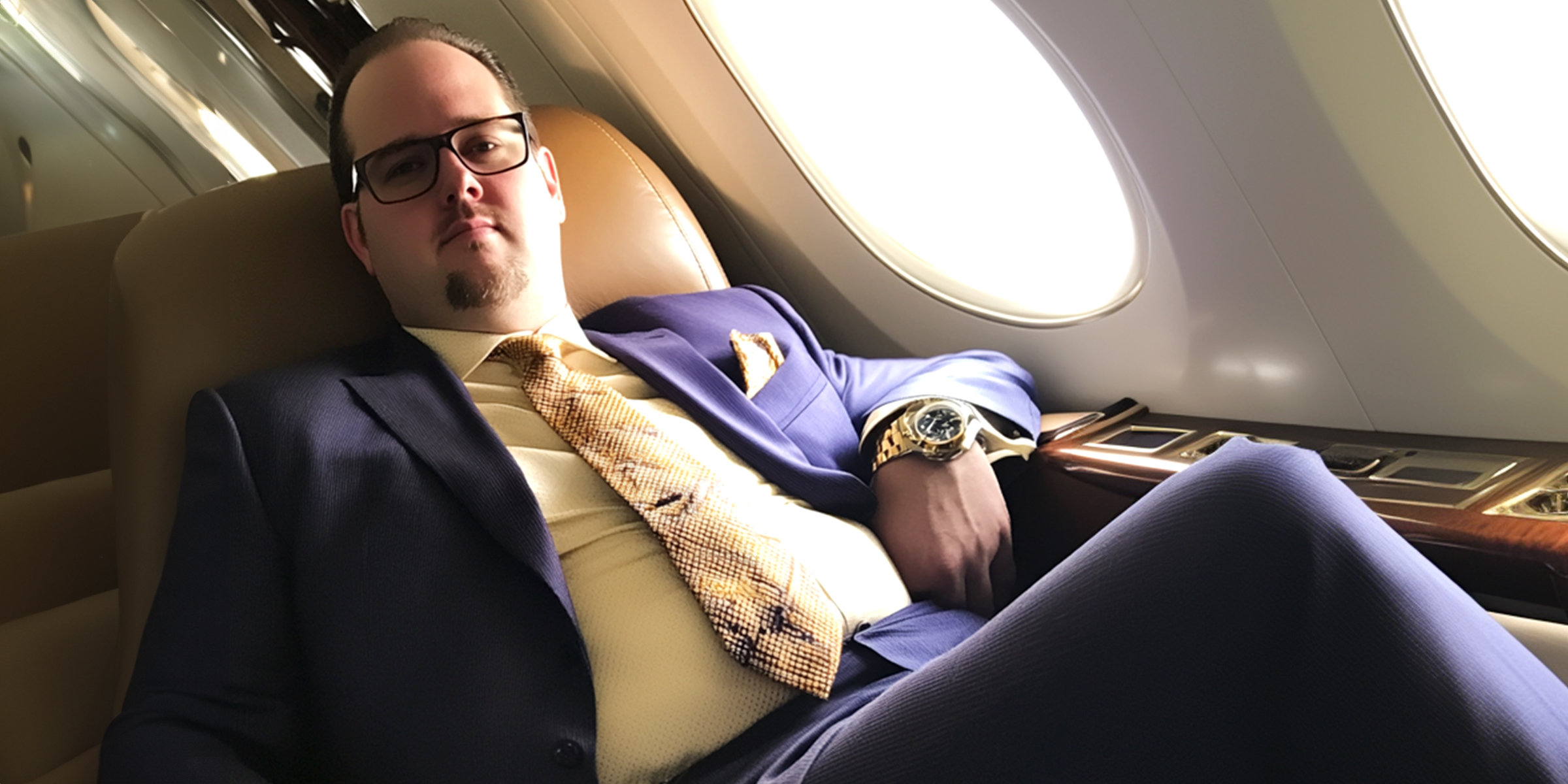 A man in a suit sitting in an airplane | Source: AmoMama