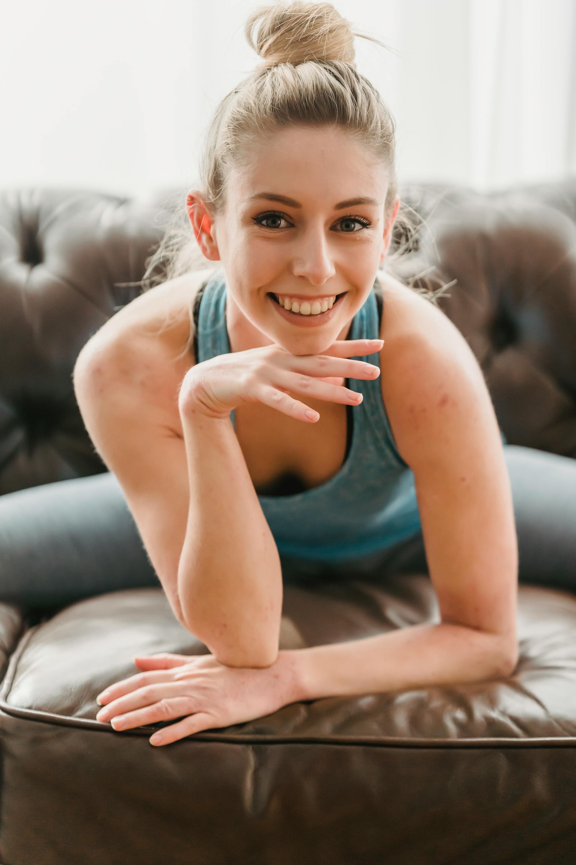 A smiling young woman sitting on a sofa | Source: Pexels