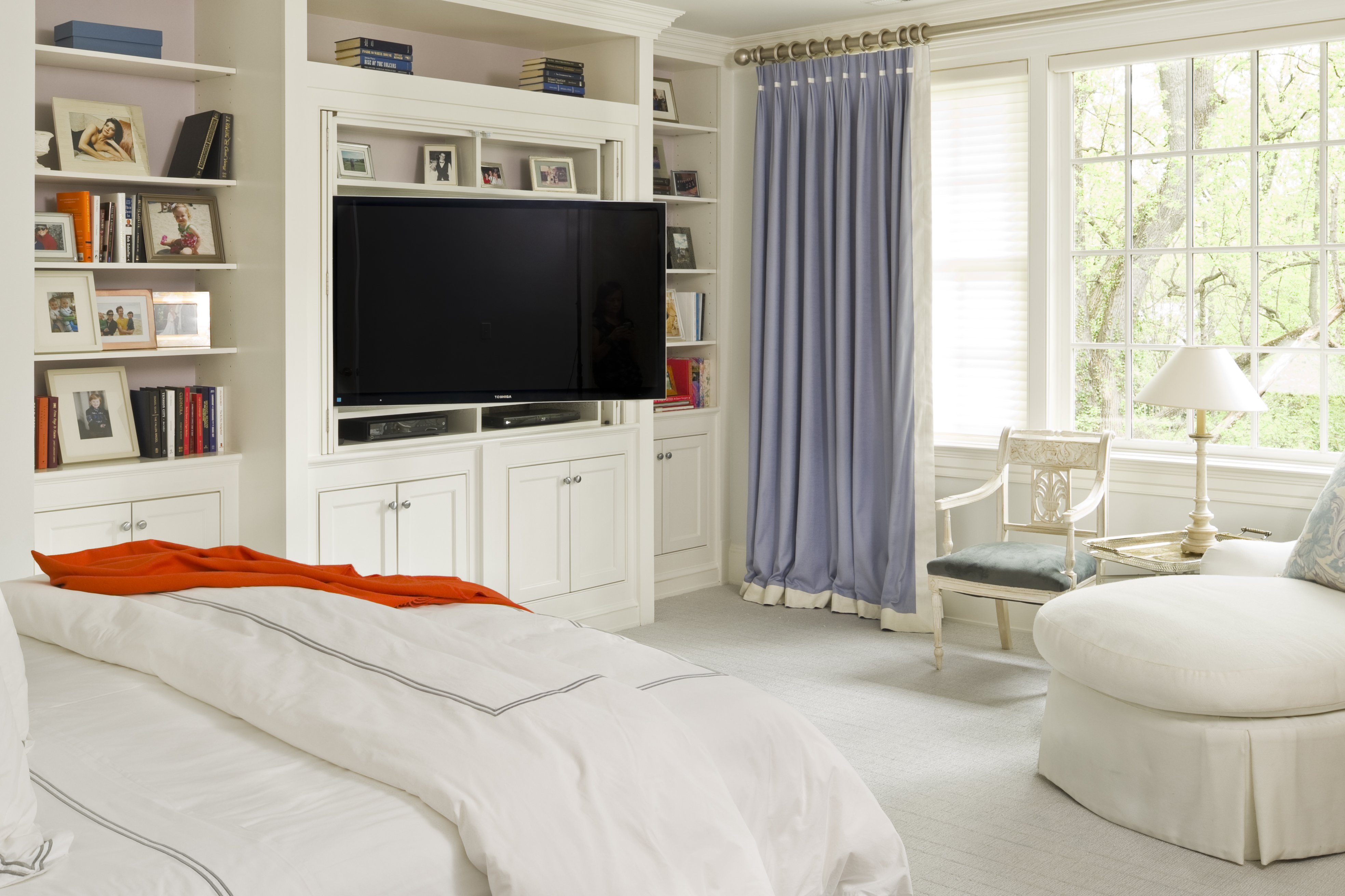 Geoff Tracy and Norah O'Donnell's son's blue and cream-white bedroom with a flat-screen TV. | Photo: Getty Images