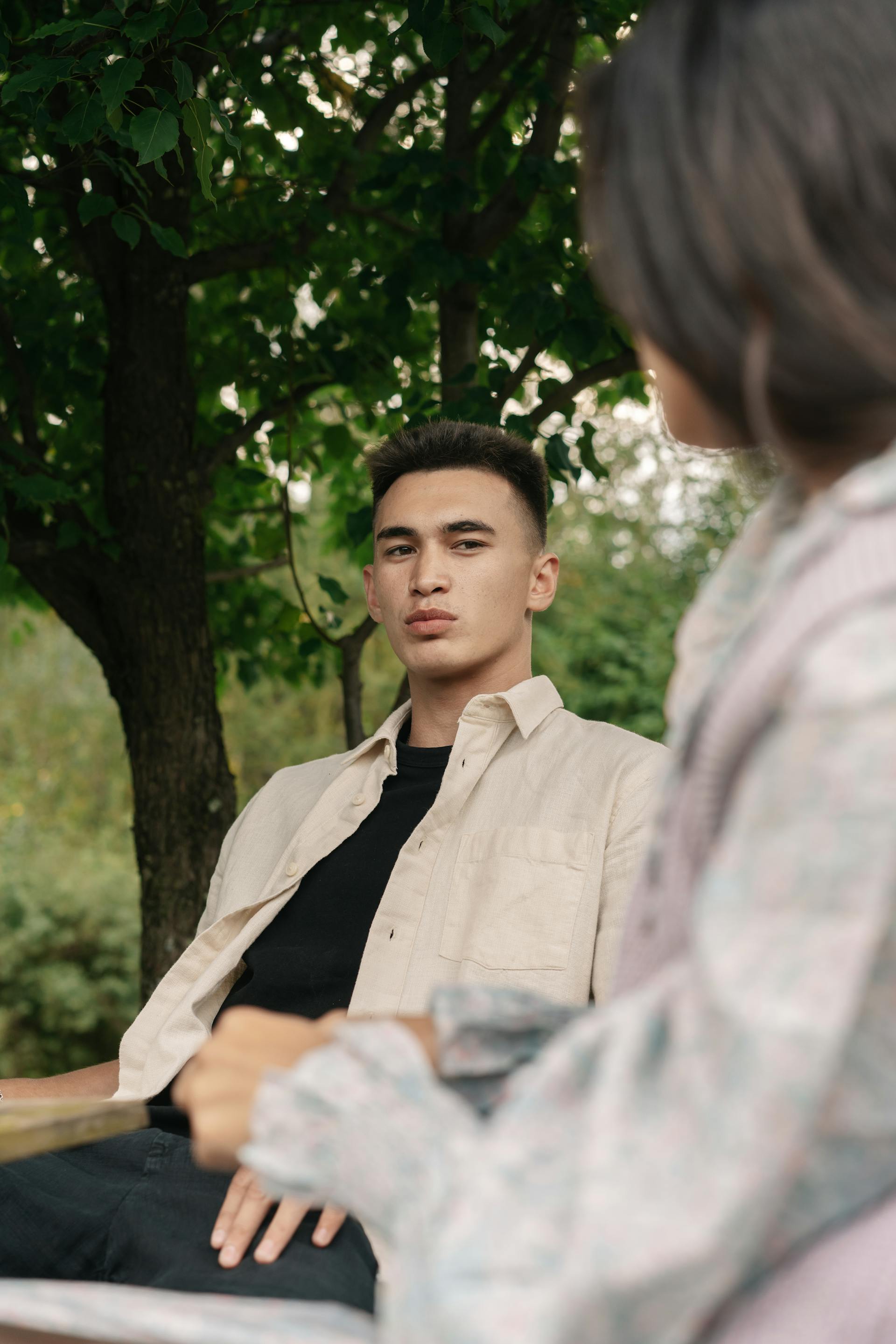 A worried man talking to a woman while sitting outside | Source: Pexels