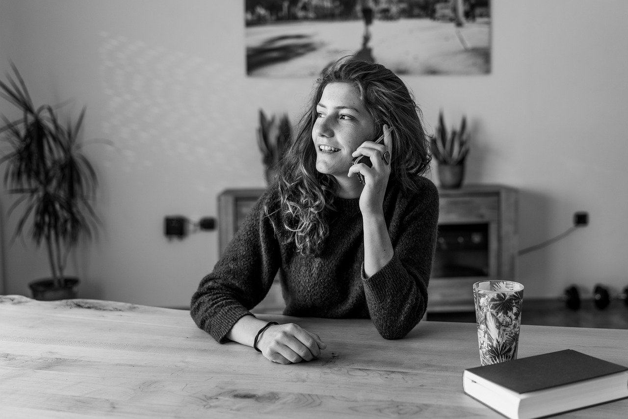 A woman smiling while talking on the phone | Source: Pexels