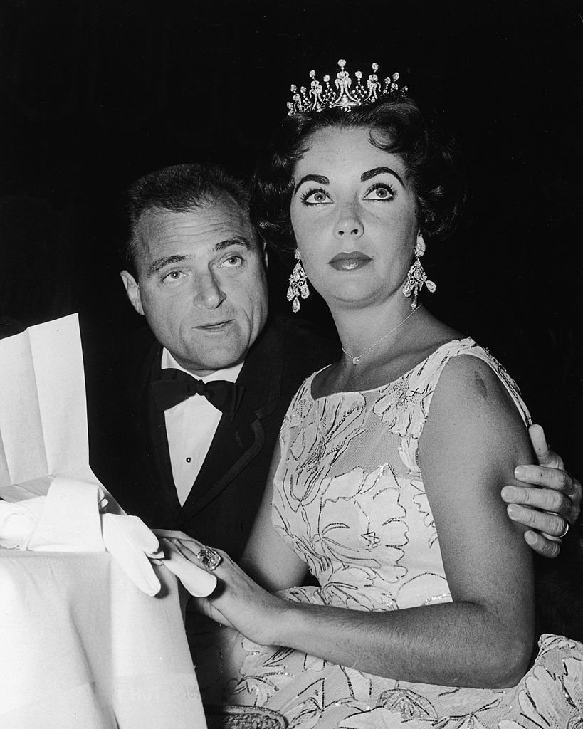 Elizabeth Taylor sits with her third husband, American film producer Mike Todd, at a Golden Globe Awards ceremony at the Coconut Grove nightclub, Hollywood, California, 1957 | Photo: Getty Images