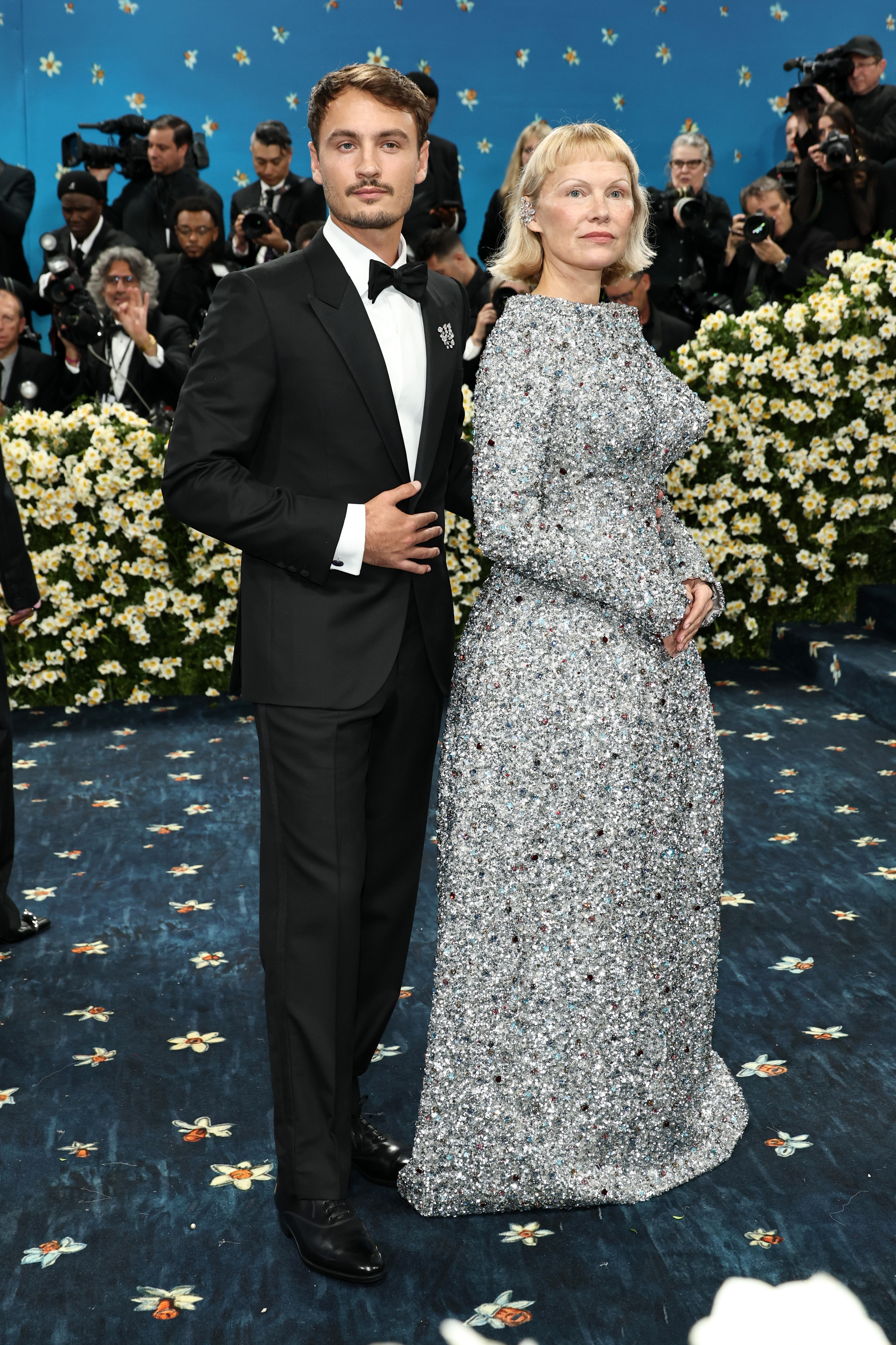 Brandon Thomas Lee and Pamela Anderson strike a composed pose at the 2025 Met Gala. Dressed in coordinated formalwear, the duo joined other stars to honor the evening's "Superfine" theme at the Metropolitan Museum of Art in New York City.