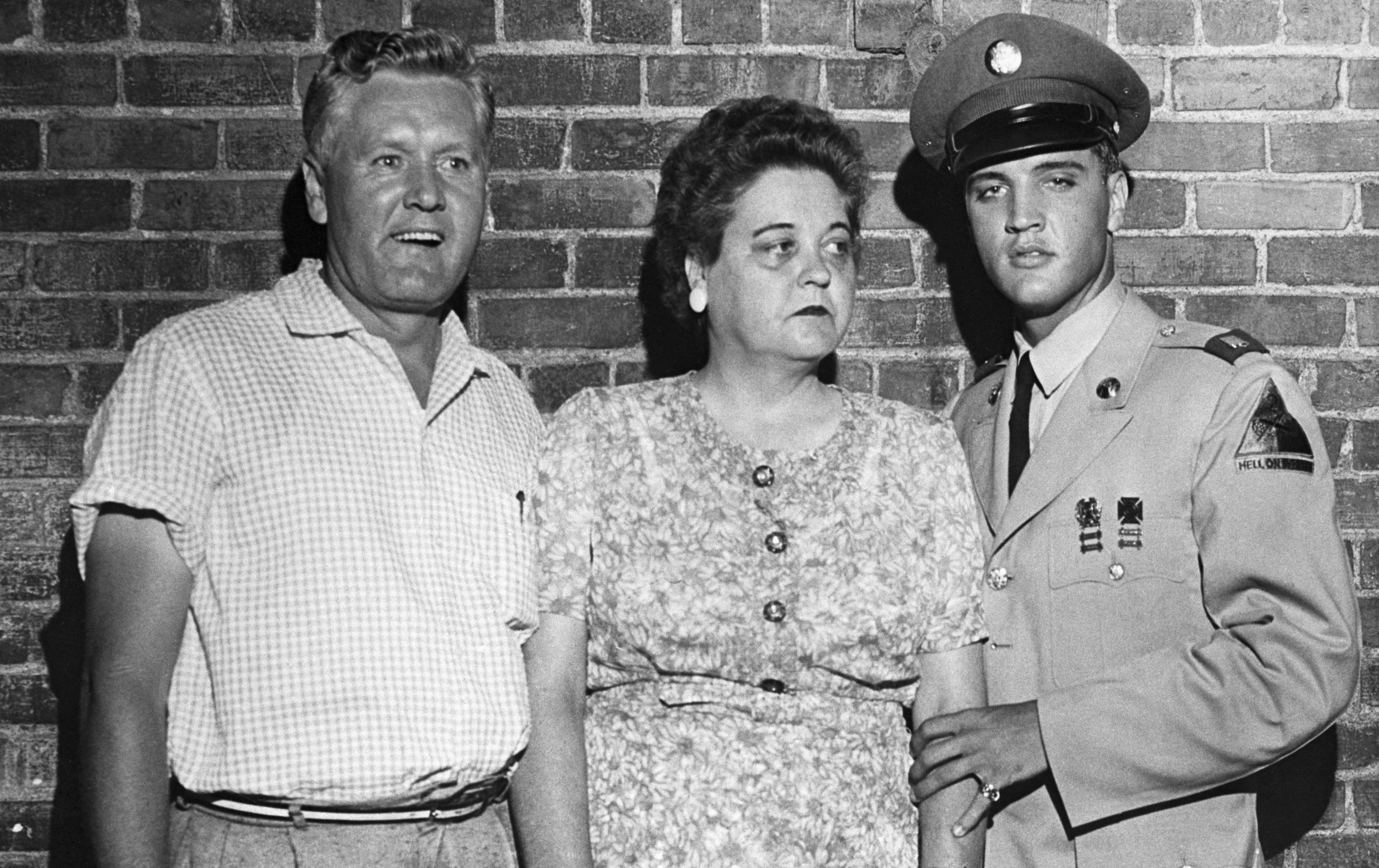Elvis Presley, on his first leave from the Army, escorts his parents, Mr. and Mrs. Presley, from their mansion here to town for a sneak preview of the entertainer's latest movie, June 1st. | Source: Getty Images
