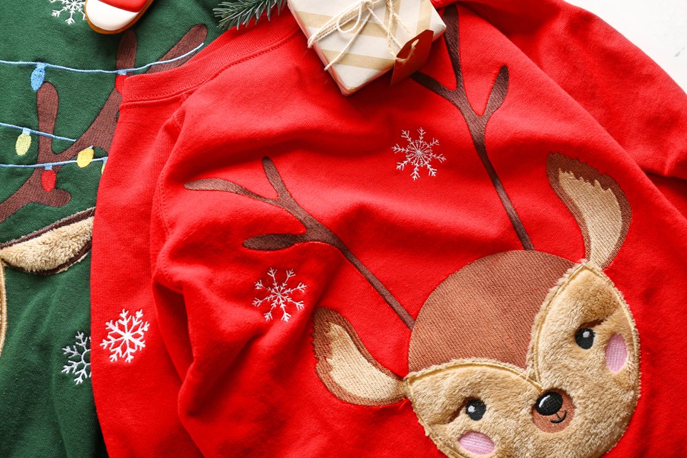 Suéter navideño de color rojo adornado con un reno confeccionado en tela. | Foto: Shutterstock