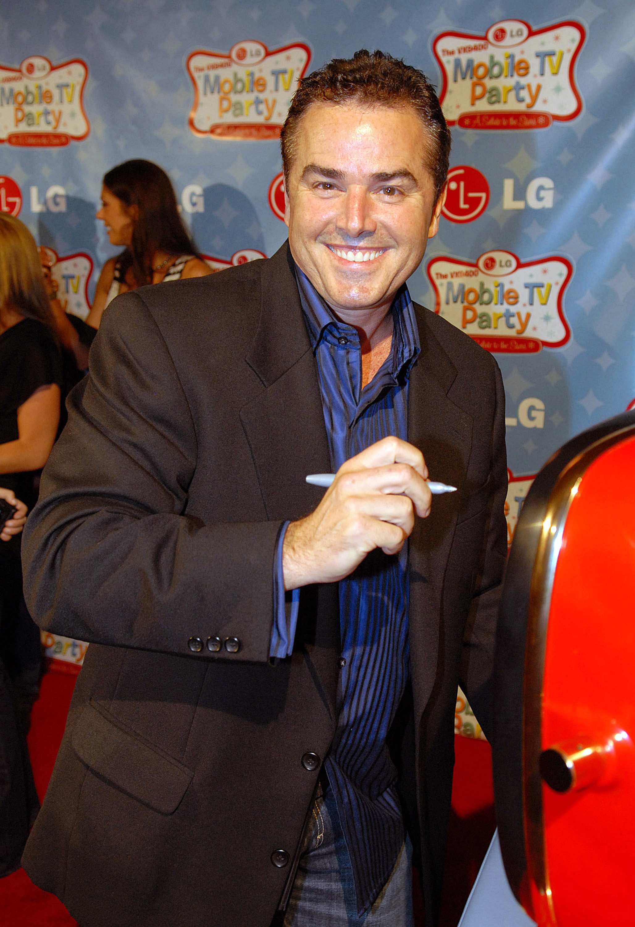 The former child actor autographs a vintage television set to be auctioned for charity at Paramount Studios on June 19, 2007 | Source: Getty Images