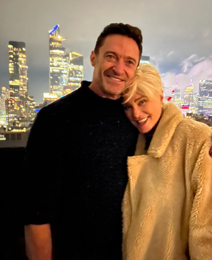 Hugh Jackman smiles beside Deborra-Lee Furness during a cozy nighttime moment with a glowing city skyline in the background as they celebrate their 27th wedding anniversary. | Source: Instagram/thehughjackman
