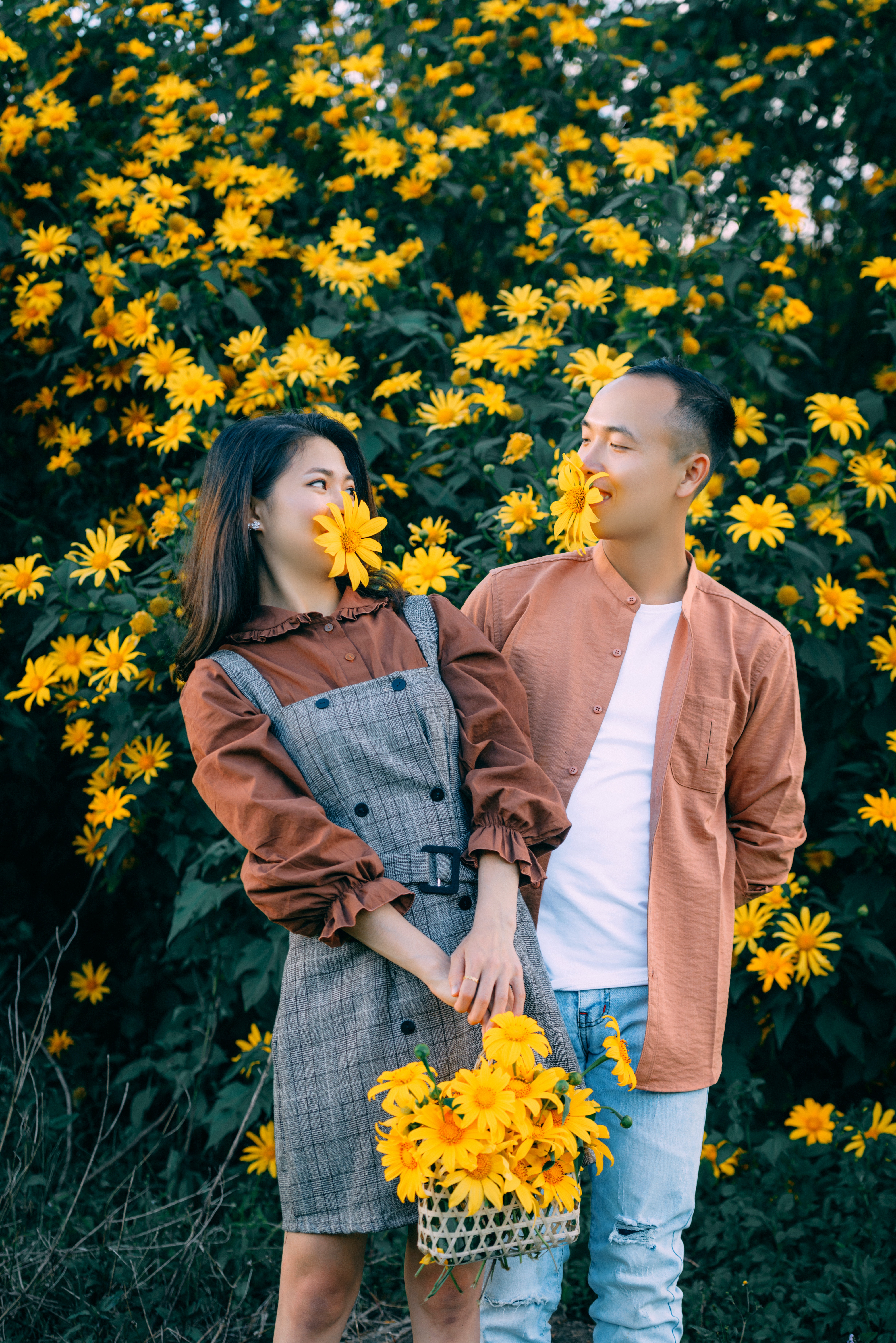 A couple with flowers in their mouths. | Source: Pexels