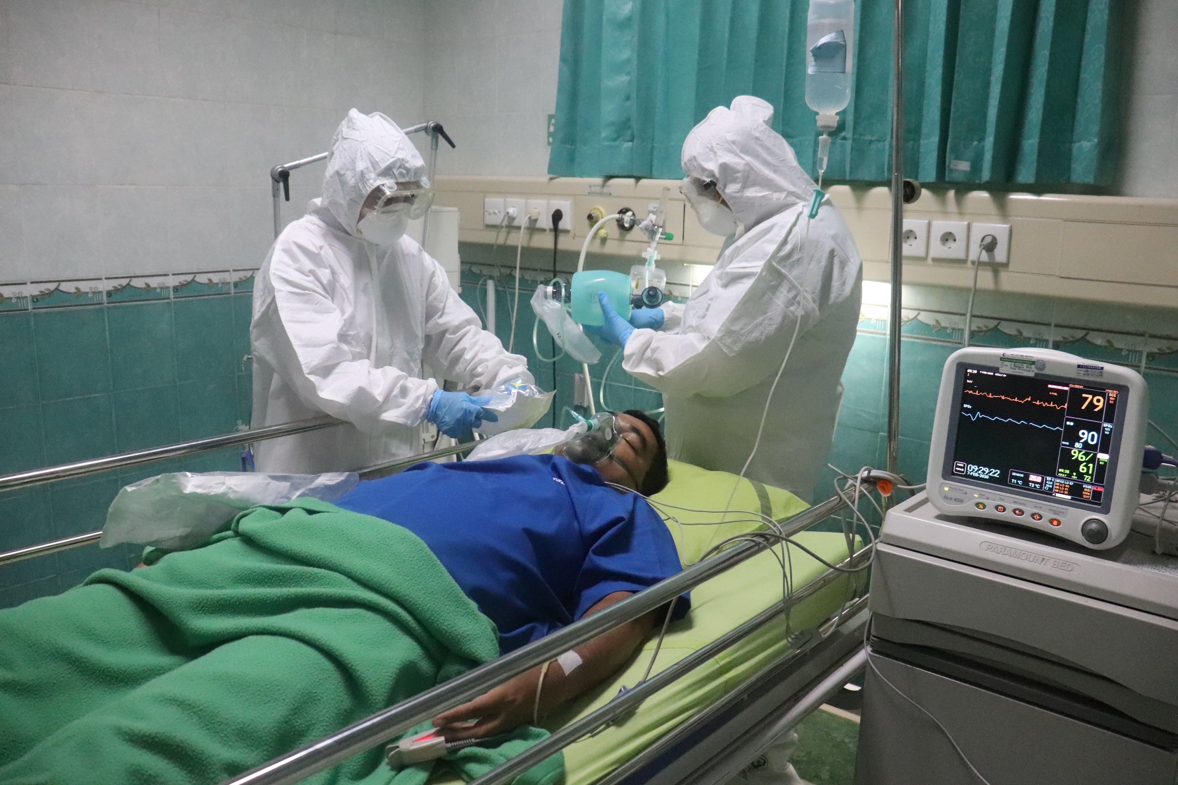 Dos médicos junto a un hombre recostado en una cama de hospital. | Foto: Unsplash