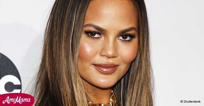 Chrissy Teigen was spotted covering her giant belly in tight leggings and sports bra